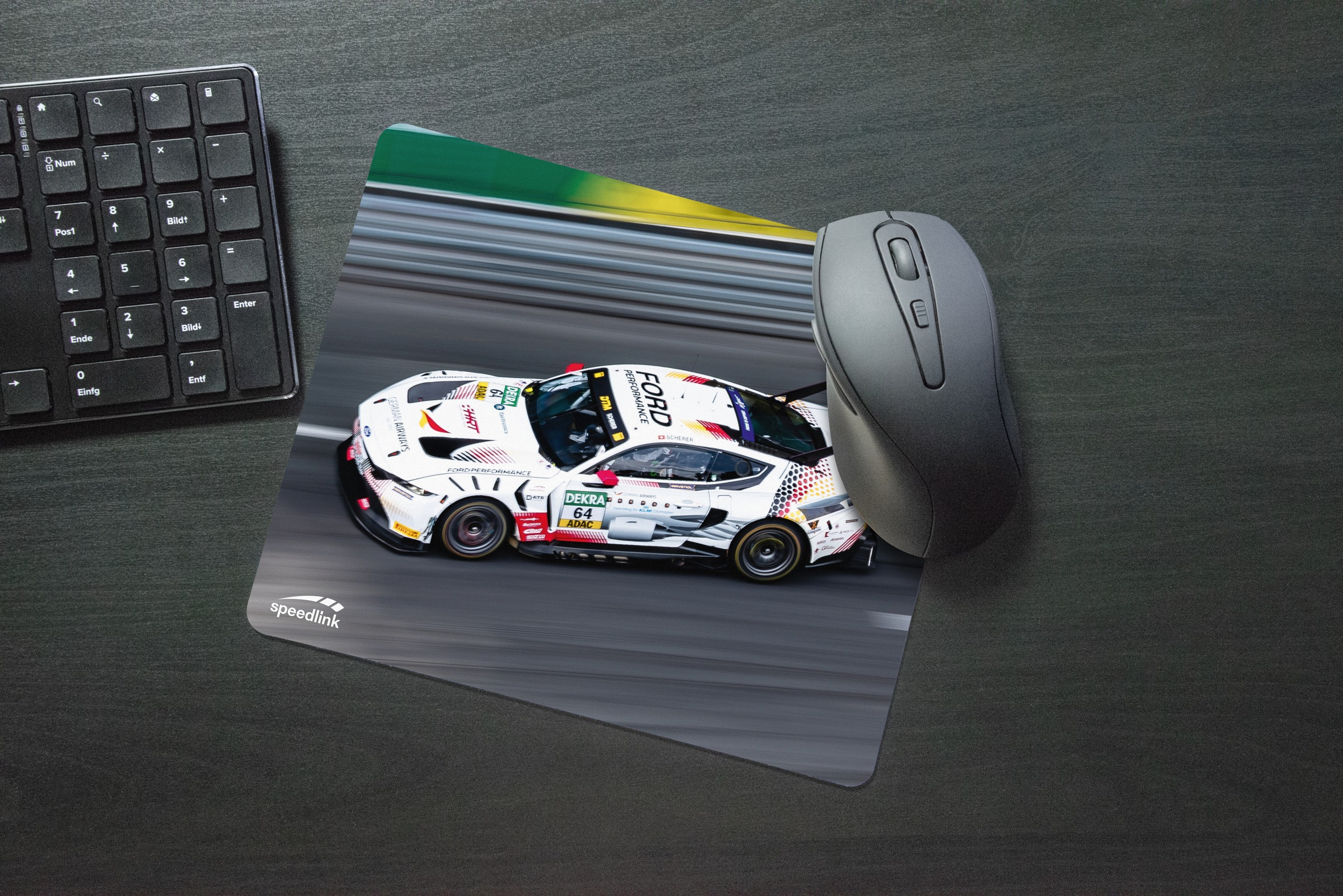 Un'auto da corsa su un tappetino per mouse accanto a tastiera e mouse.