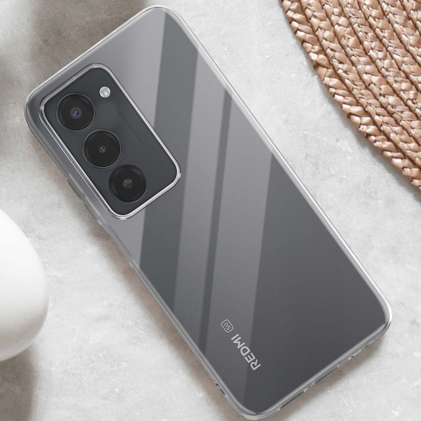 Un telefono trasparente con tre fotocamere e logo 'Redmi 5G' su un tavolo di pietra.