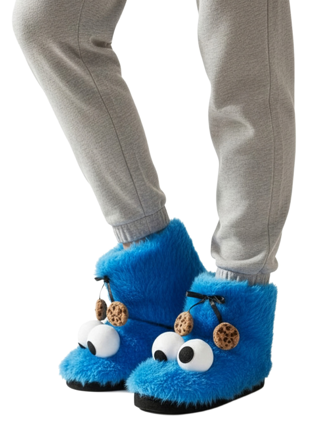 Blaue Krümelmonster-Hausschuhe mit Augen und Keksen, getragen mit grauer Jogginghose.