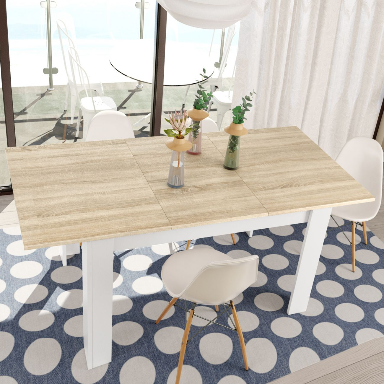Una mesa de madera clara con patas blancas sobre una alfombra azul con círculos blancos.