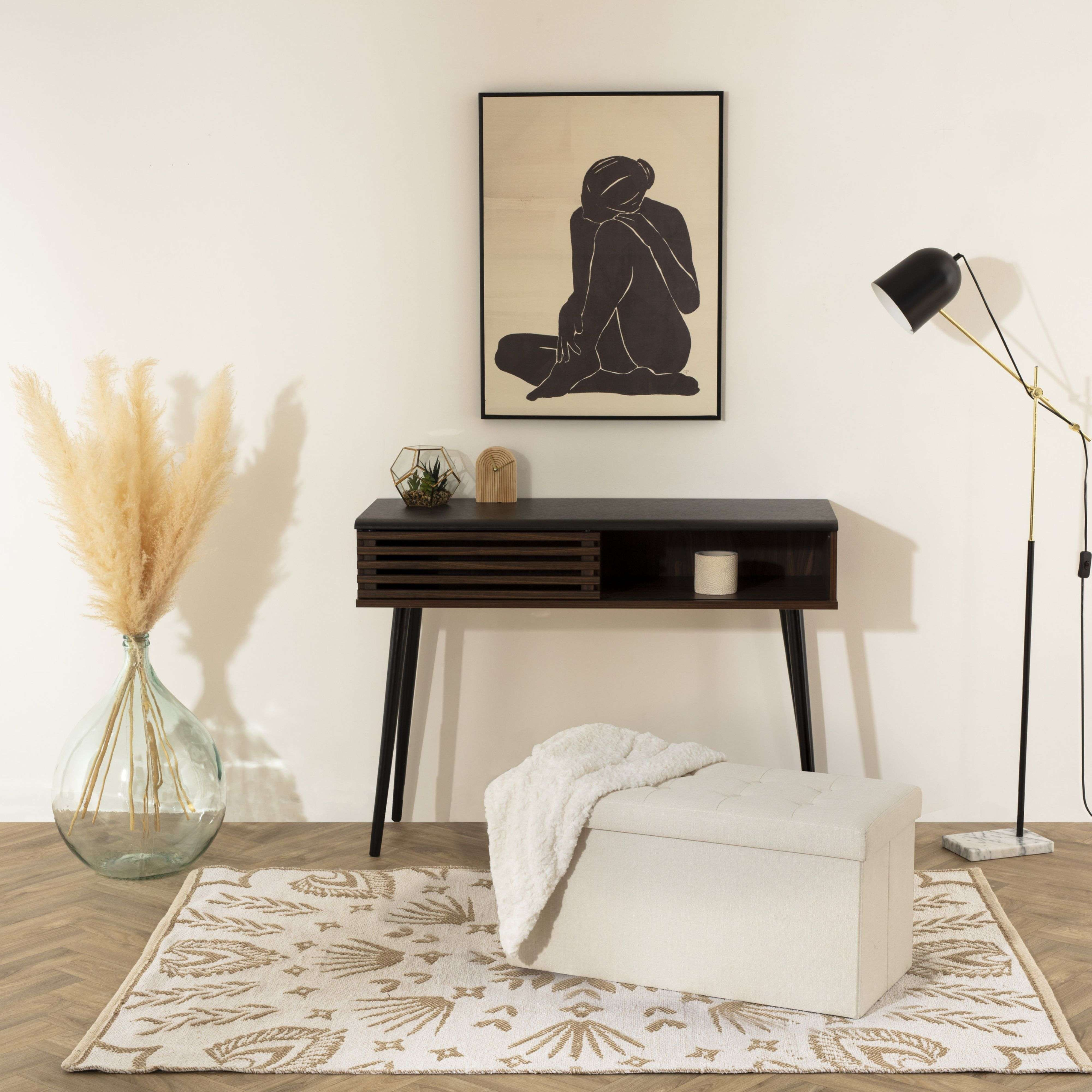 Una mesa consola marrón oscuro con decoración está sobre una alfombra.