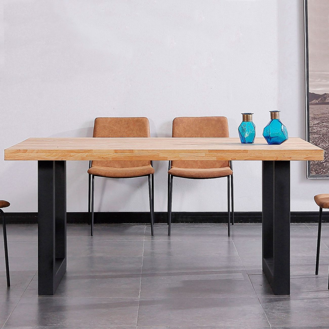 Una mesa de madera con patas negras, dos sillas marrones y jarrones azules.
