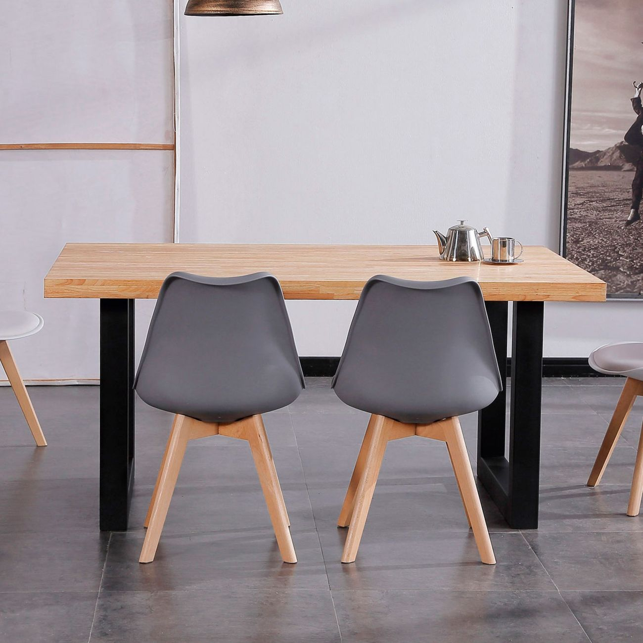 Una mesa de madera con sillas y una tetera se asienta en un suelo de baldosas.