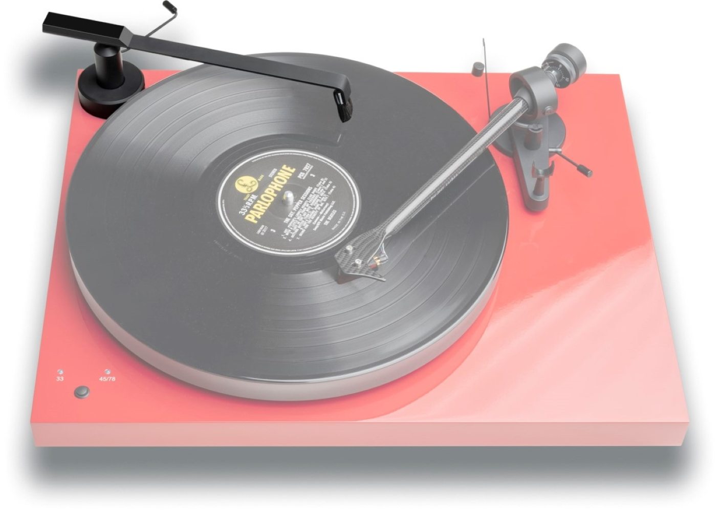 Czerwony gramofon z czarną płytą i ramieniem.