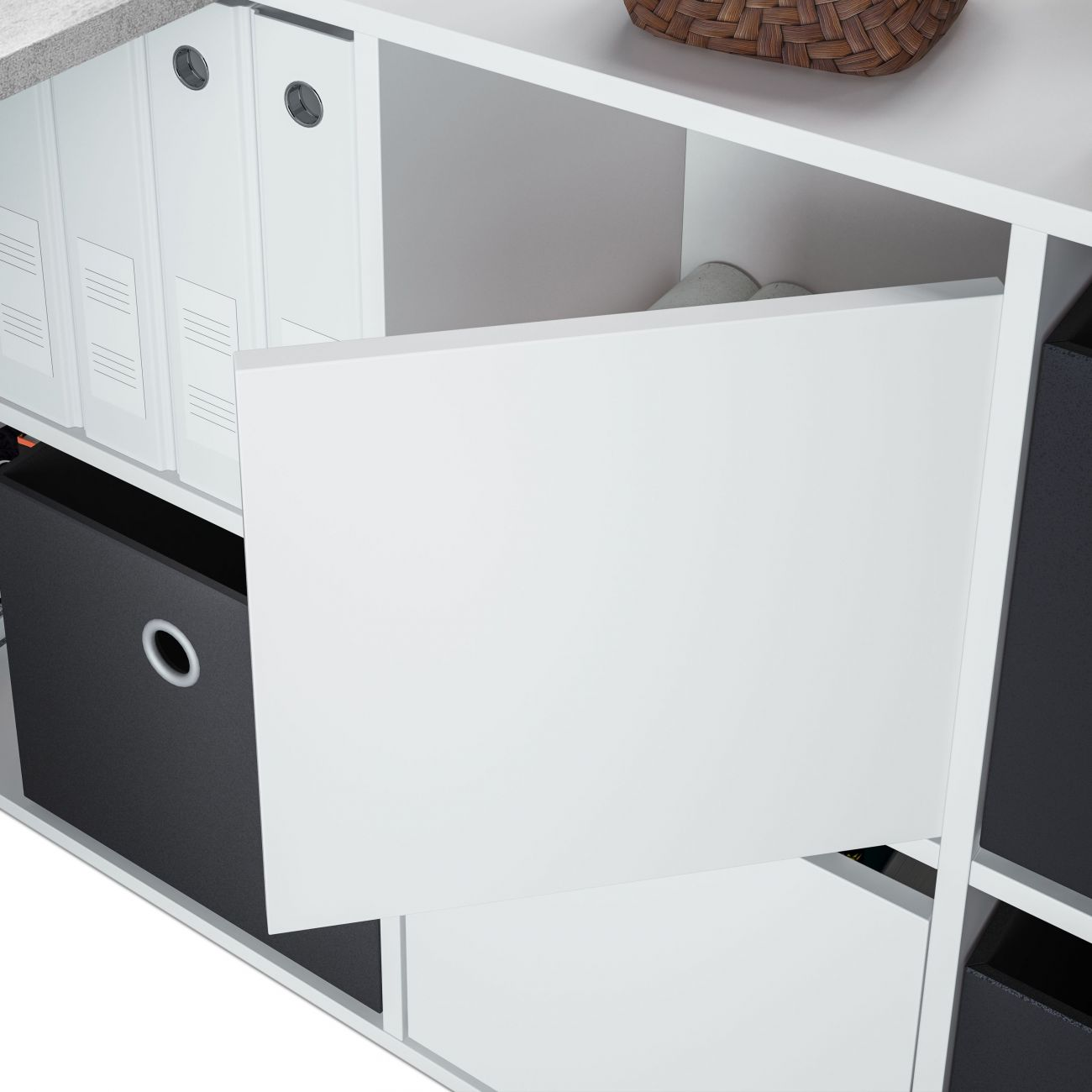 Un estante blanco con carpetas y cajas de almacenaje negras.
