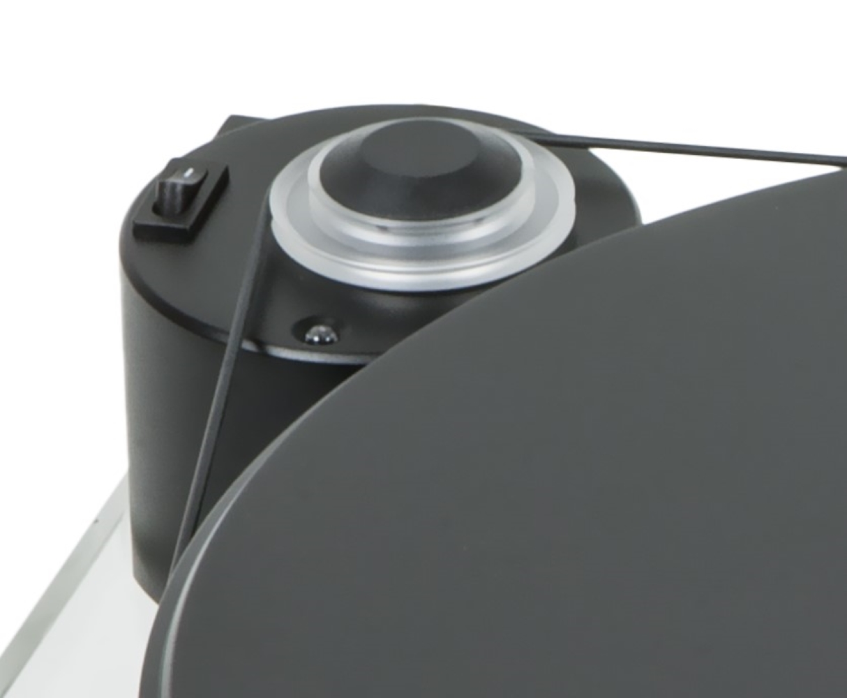 Czarny silnik gramofonu z włącznikiem i kołem pasowym, widziany z boku.