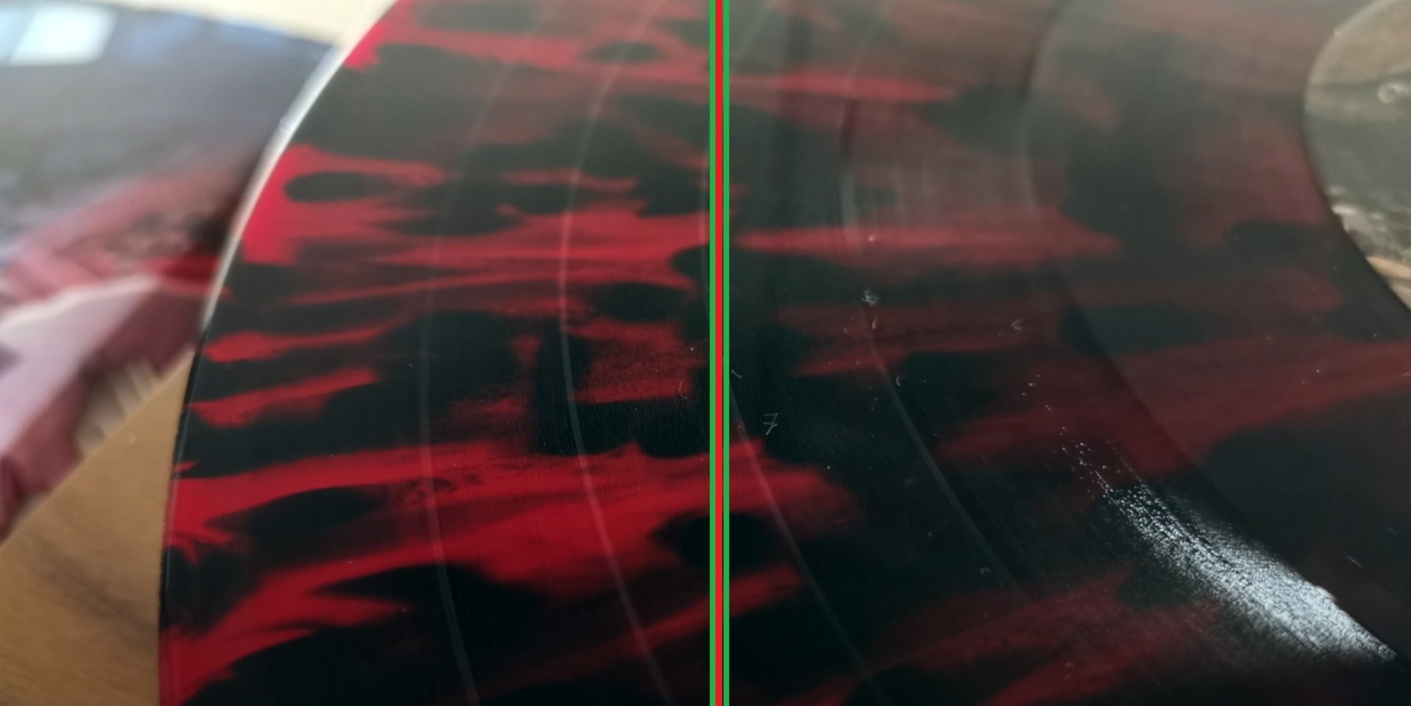 Płyta winylowa z czerwonym wzorem marmuru i rowkami, podzielona czerwoną i zieloną linią.