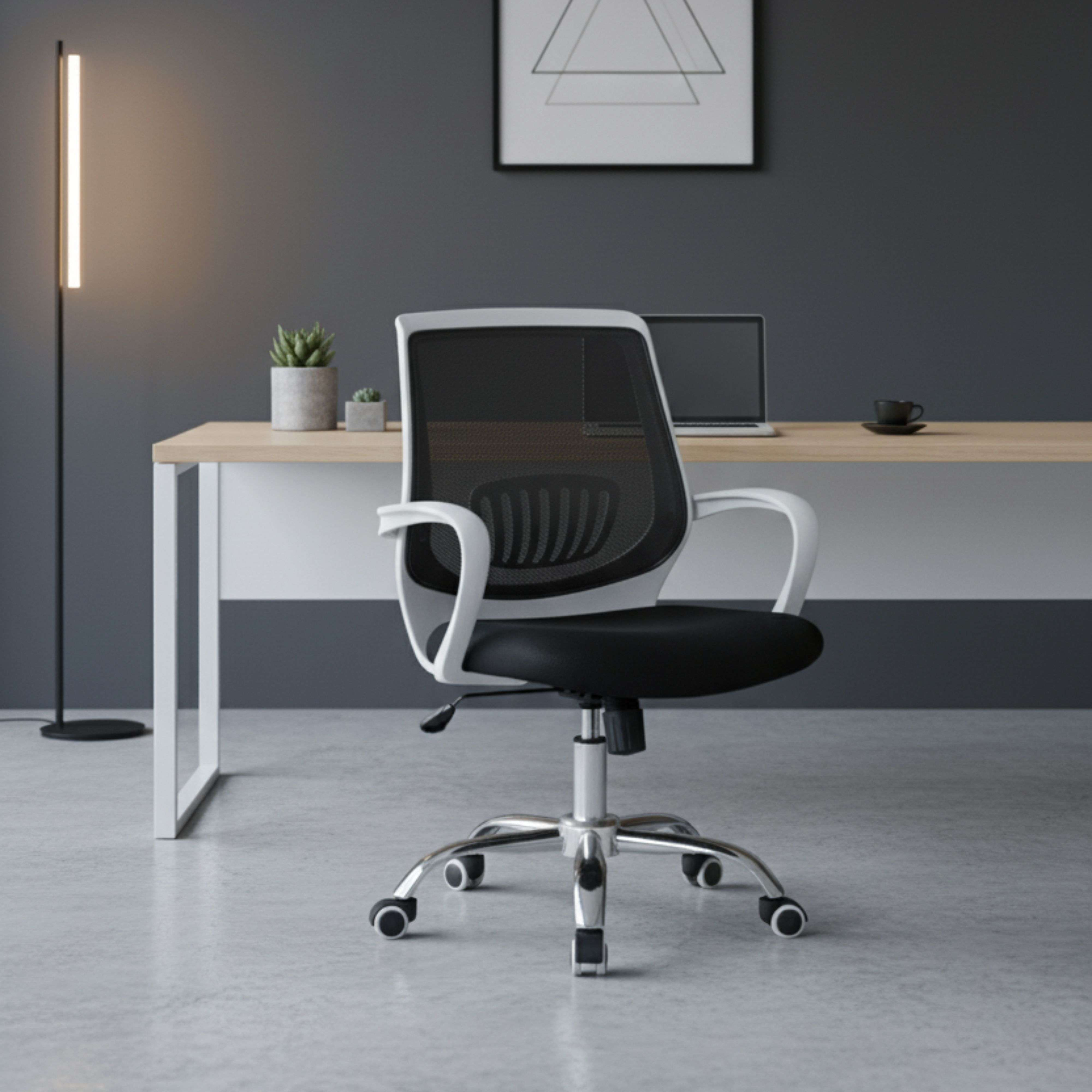 Una silla de oficina blanca con respaldo de malla negra está frente a un escritorio.