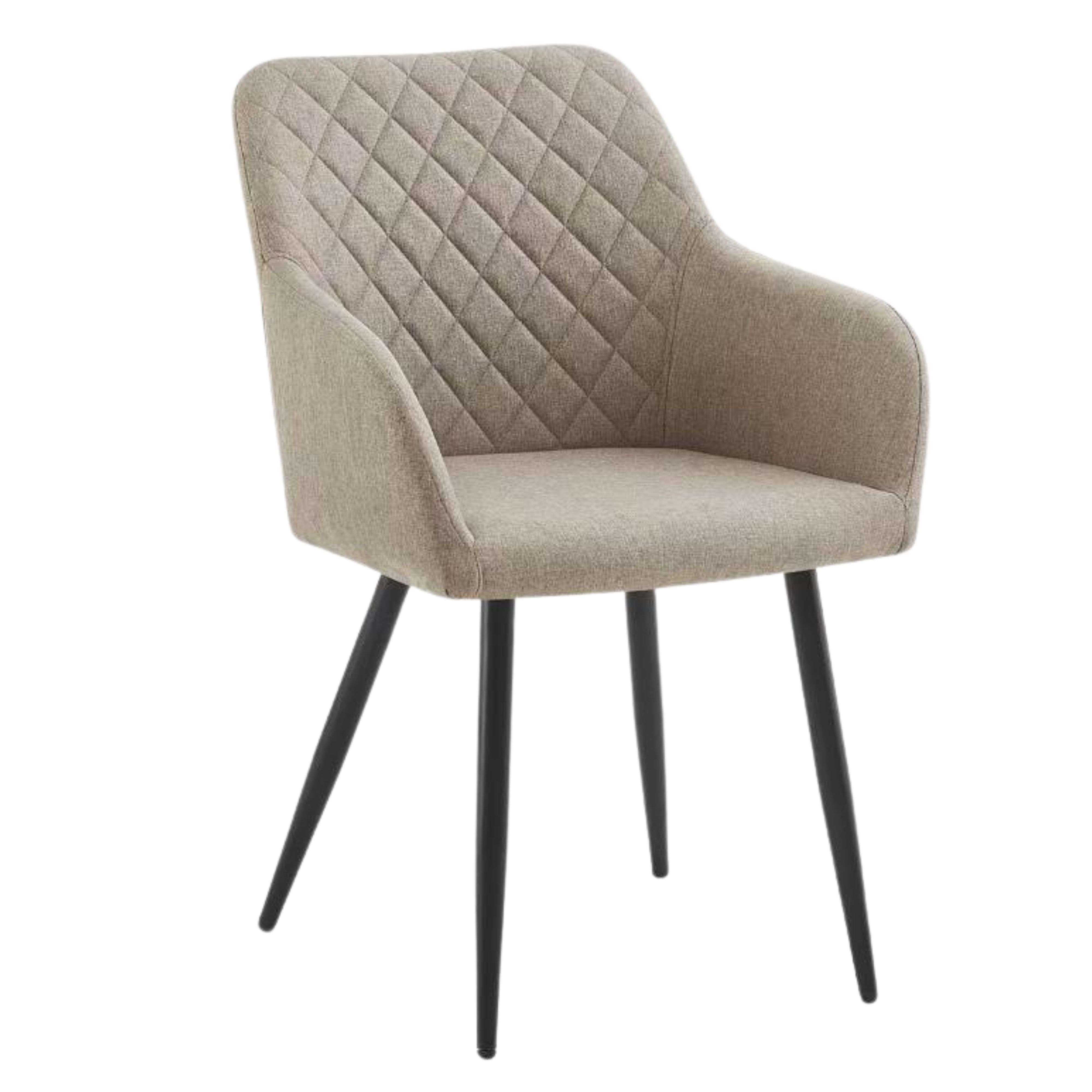 Un sillón beige con acolchado de diamantes y patas negras.