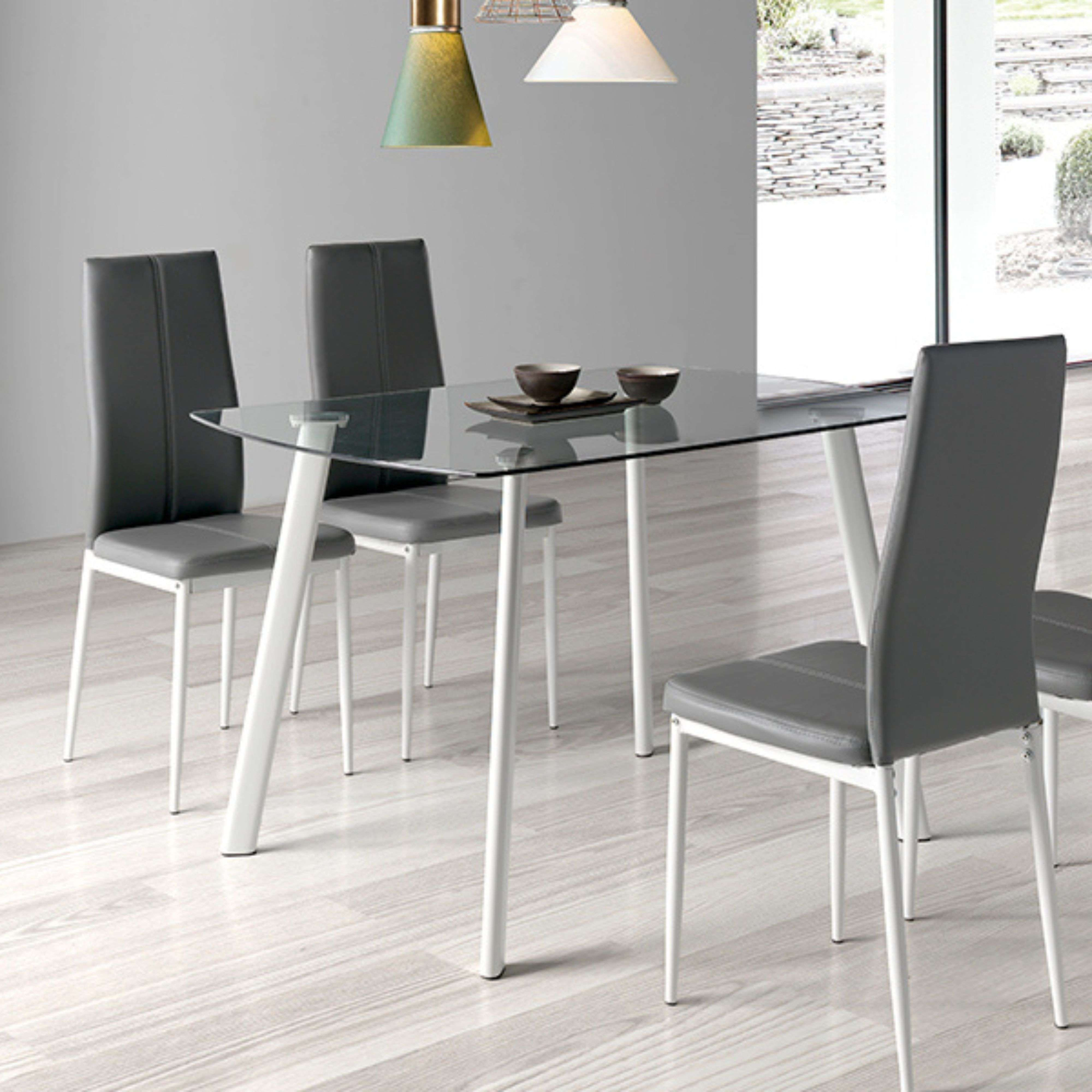 Una mesa de cristal con cuatro sillas grises en un comedor moderno.