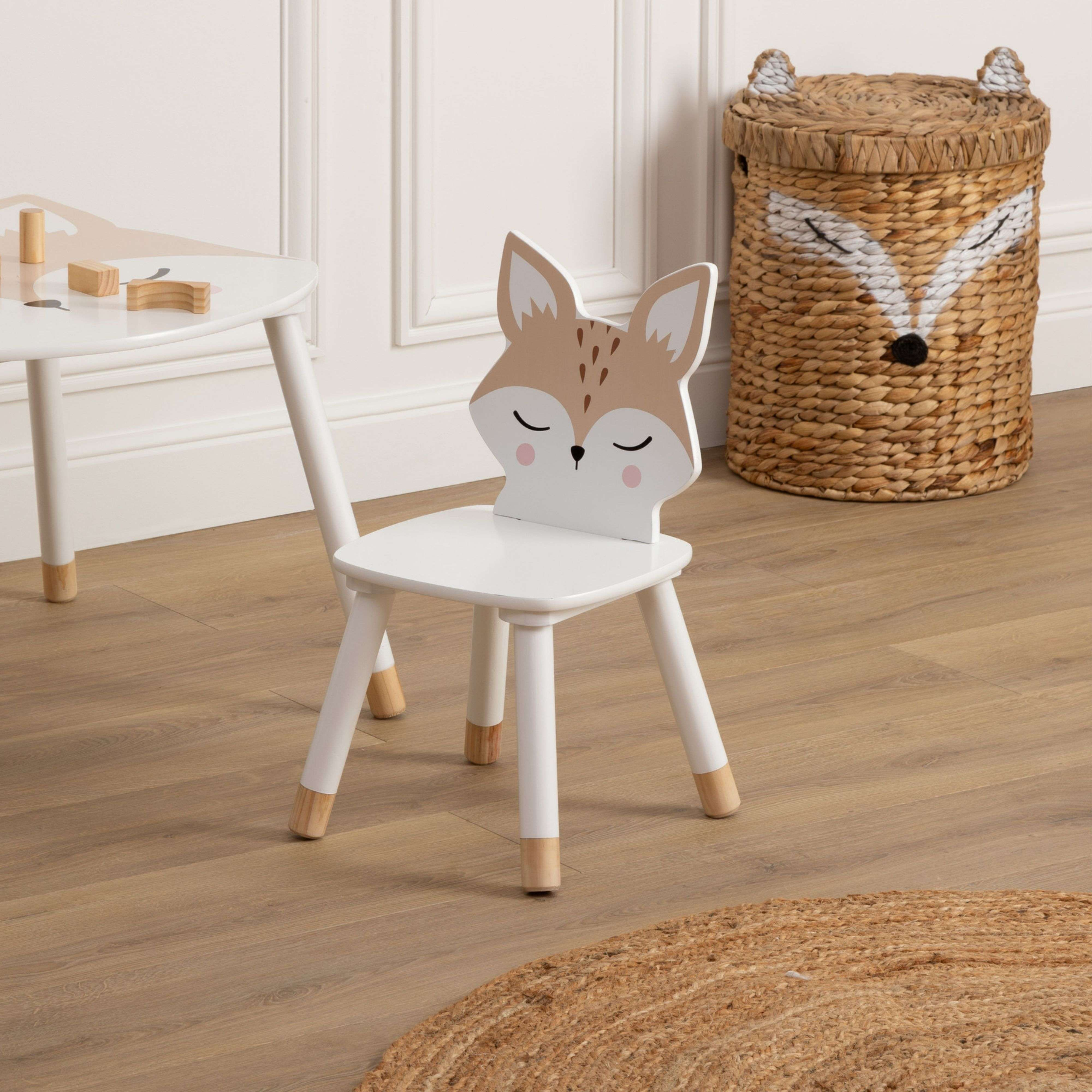 Mesa y silla infantil blanca con diseño de zorro, junto a una cesta.