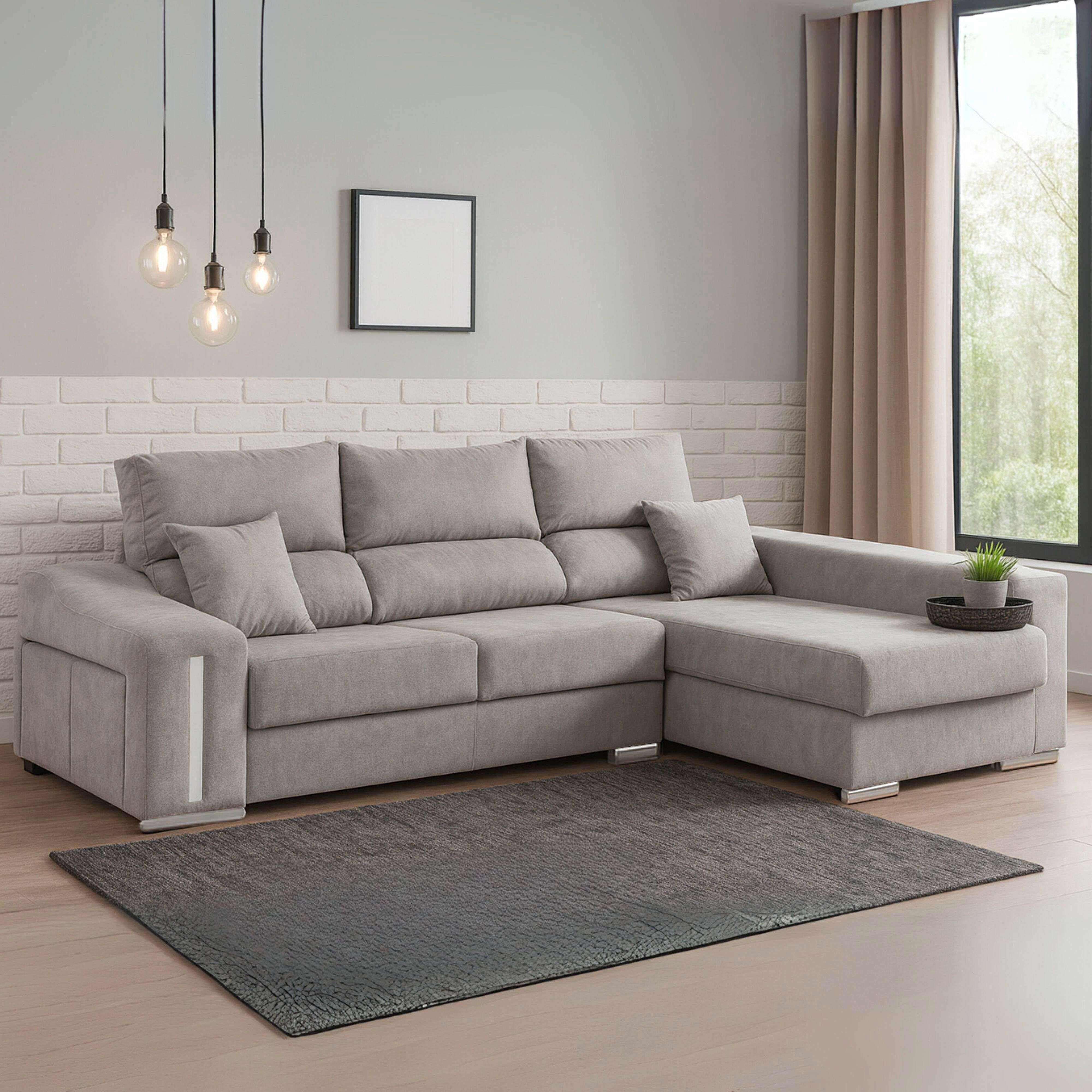 Sofá seccional gris con cojines sobre suelo de madera con alfombra.