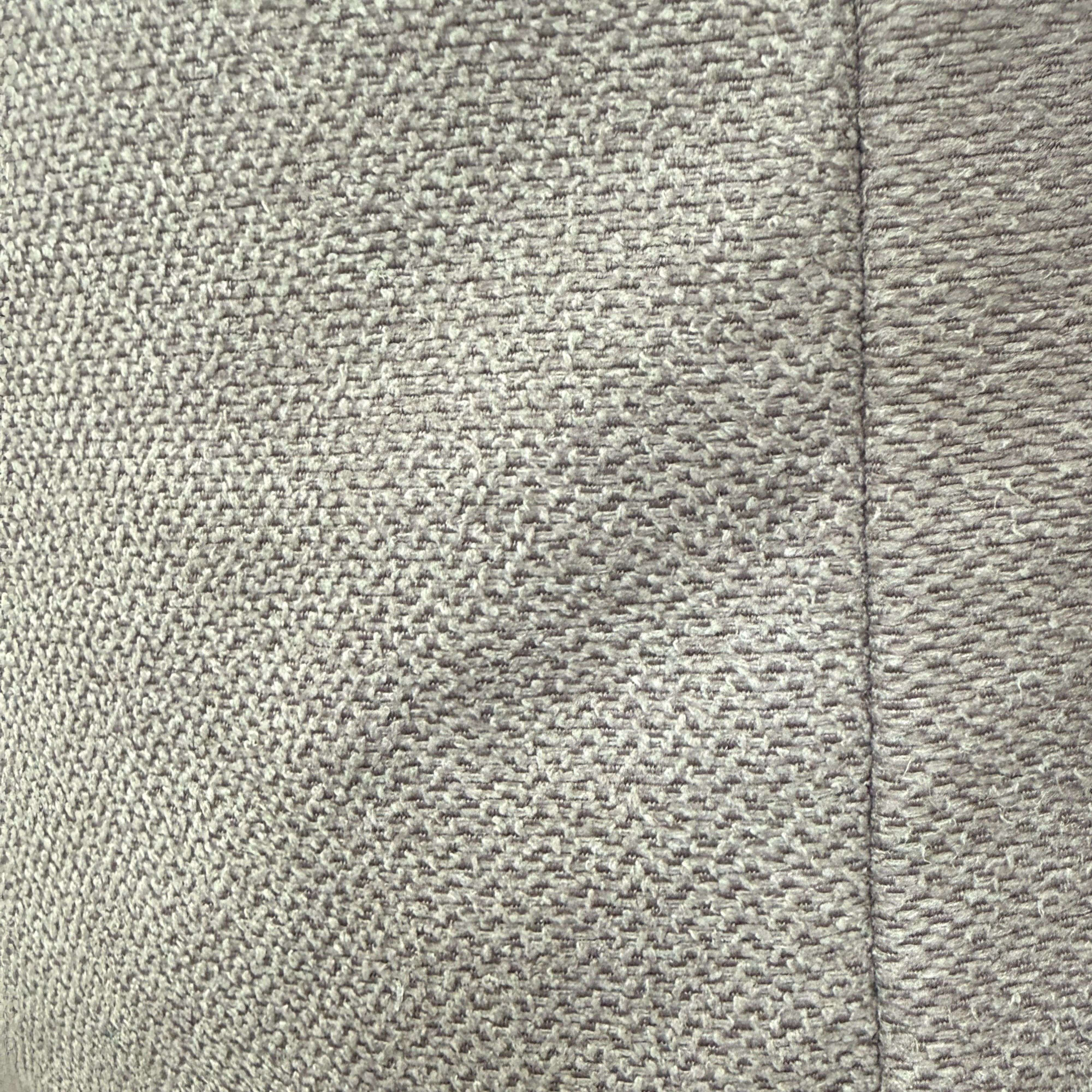 Tejido gris con costura visible.