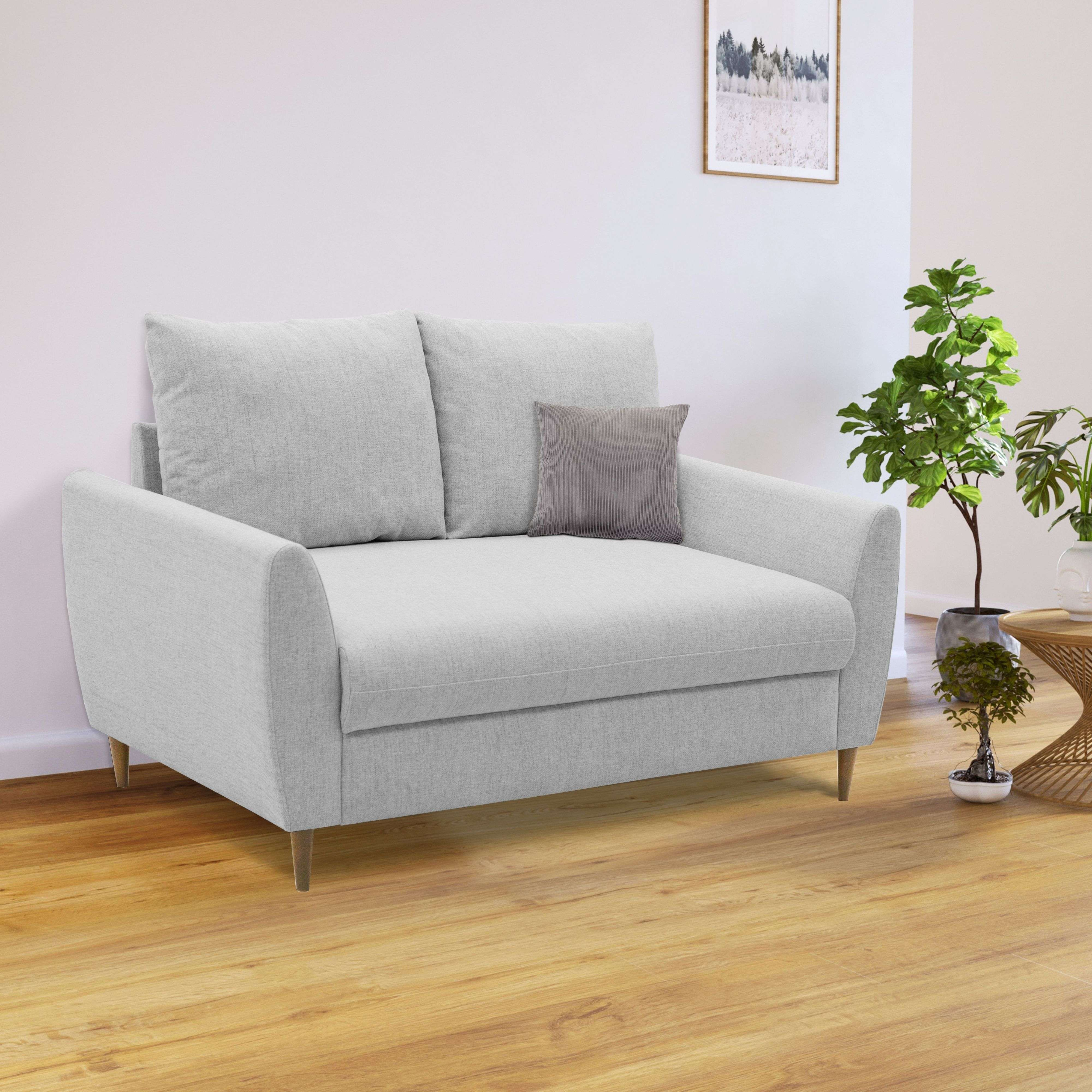 Un sofá gris claro con dos cojines y un pequeño cojín decorativo gris.