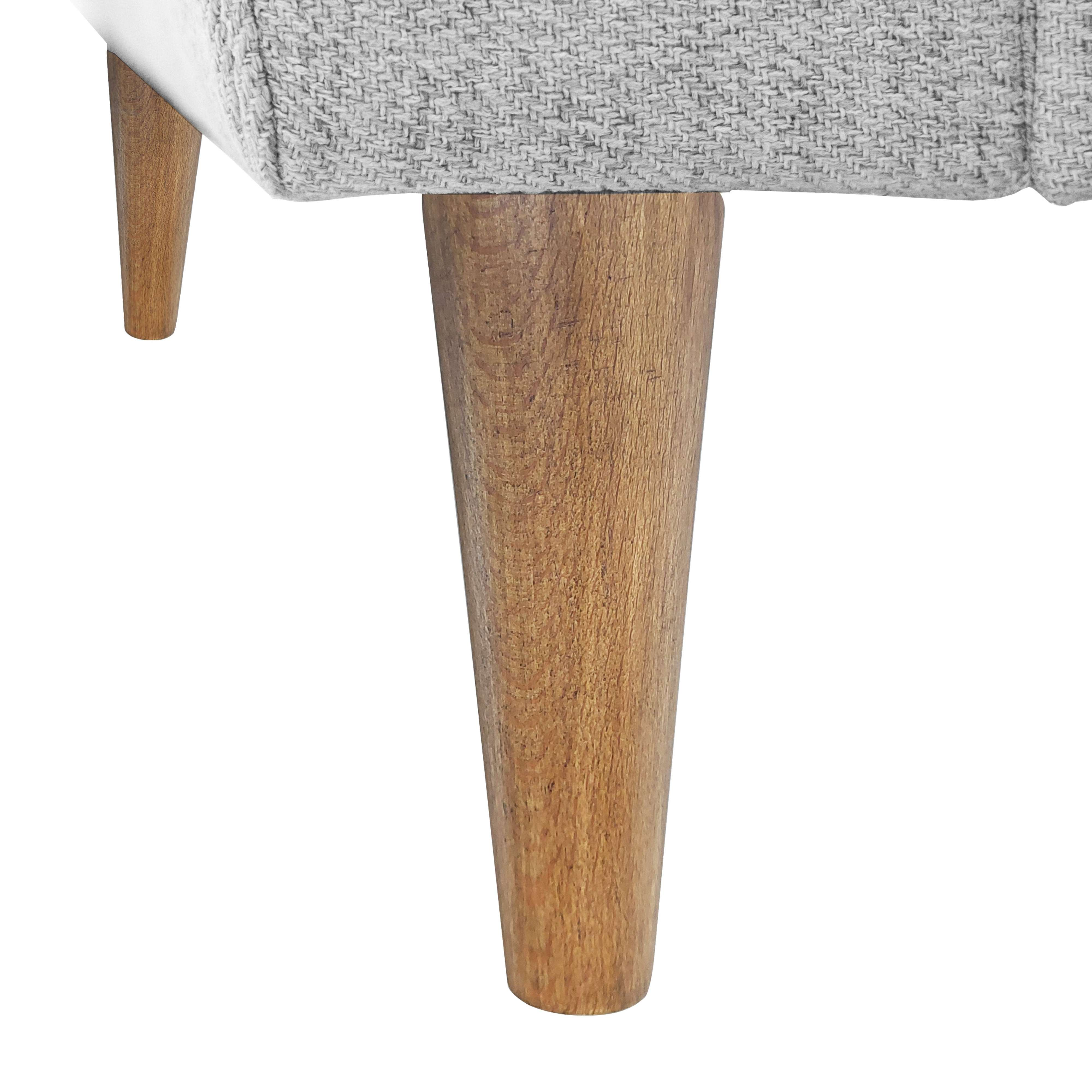 Primer plano de dos patas de madera de un sofá gris sobre fondo blanco.