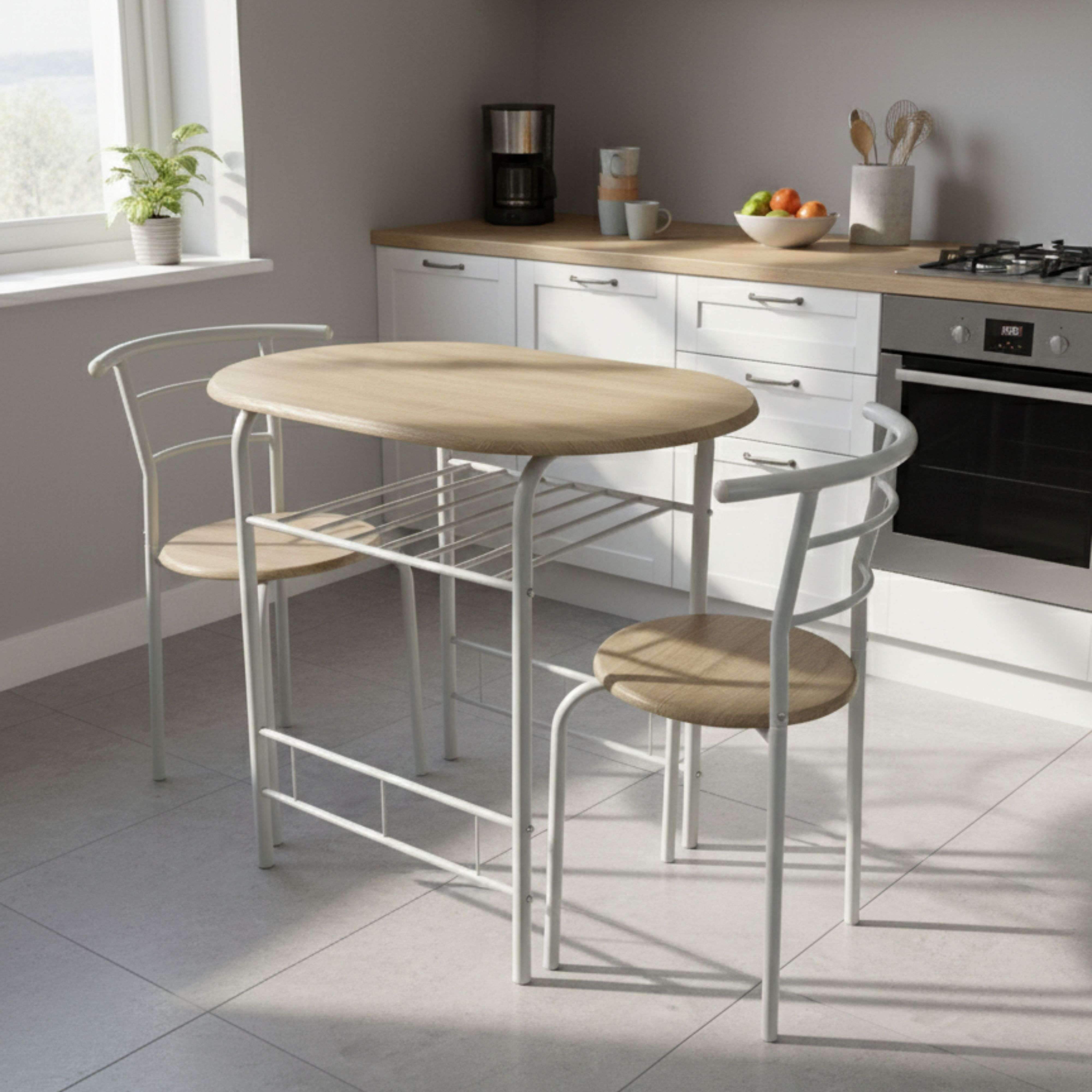 Una mesa ovalada de madera con patas de metal blanco y dos sillas en una cocina.