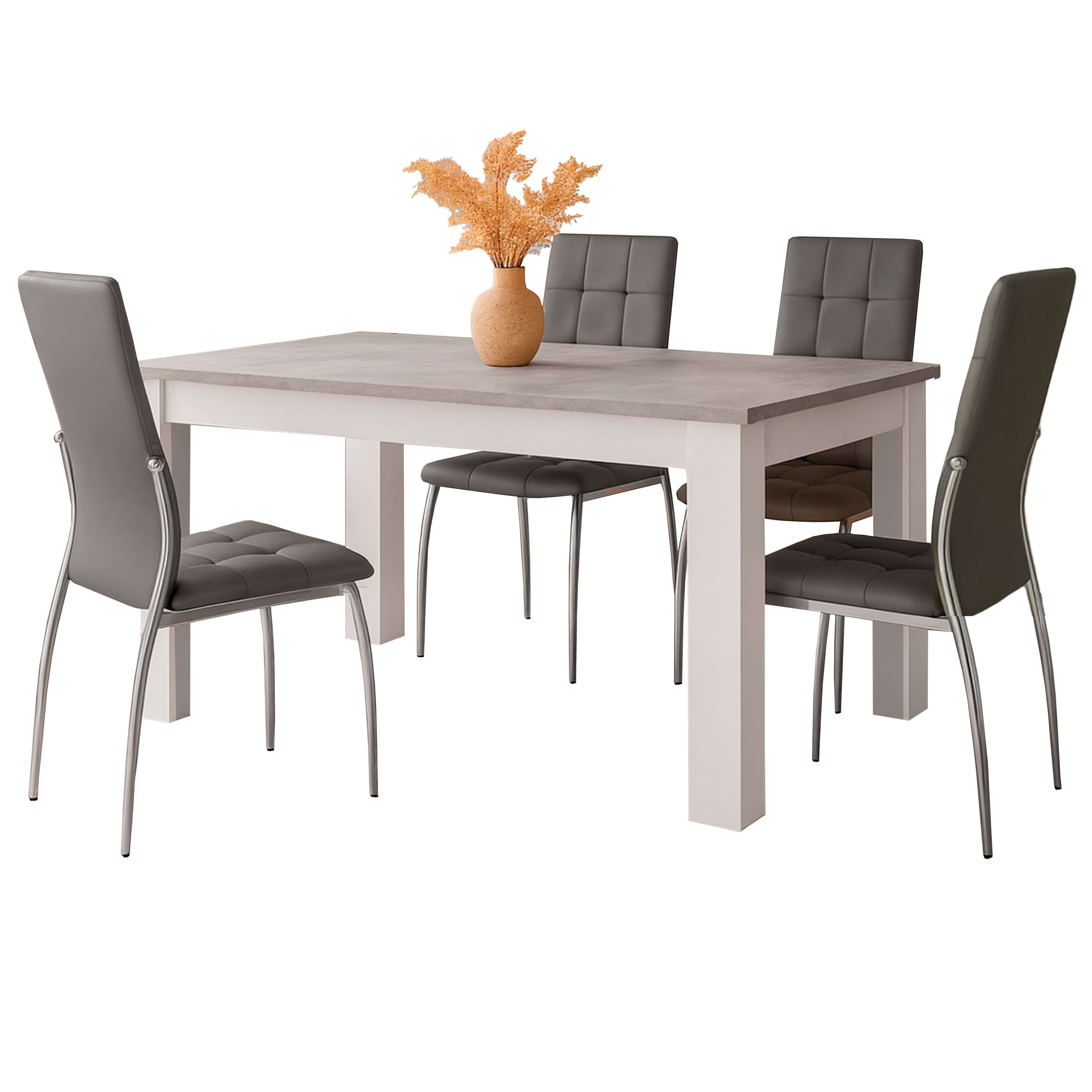 Una mesa de comedor con cuatro sillas grises y un jarrón con flores secas.