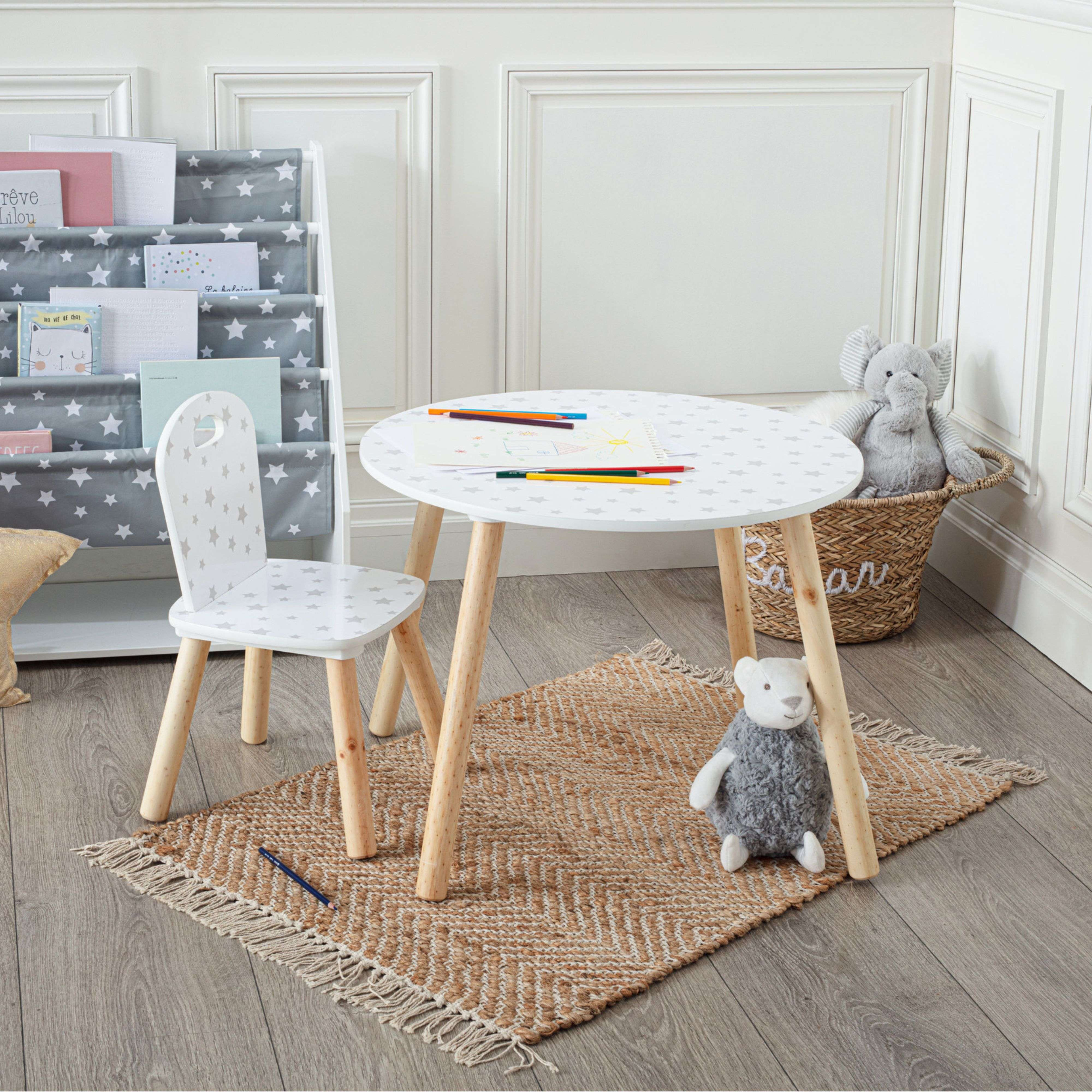 Mesa y silla infantil, elefante de juguete y oso de peluche sobre alfombra.