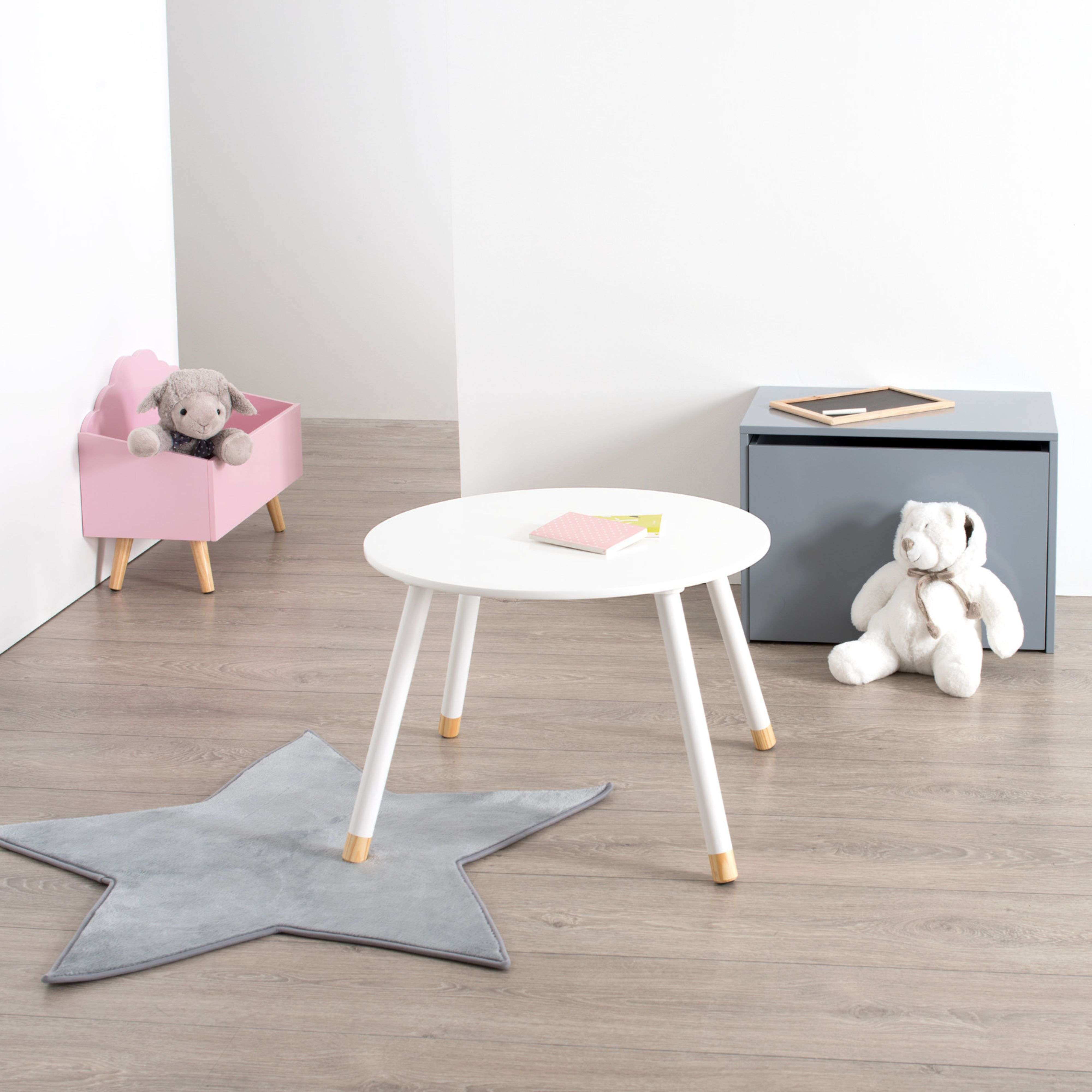 Un oso de peluche blanco se sienta junto a un cofre gris con una pizarra.