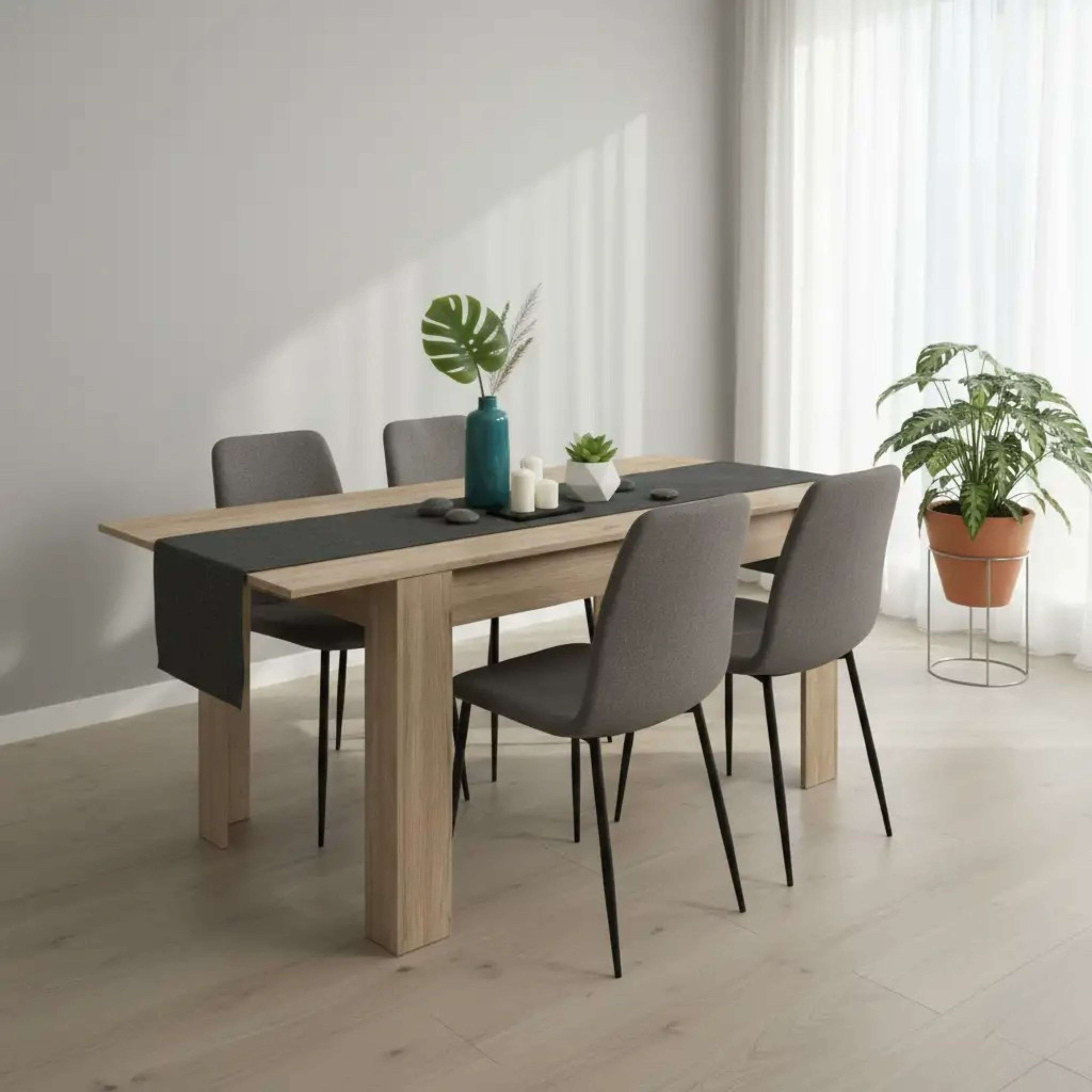 Mesa de madera con sillas grises, decorada con jarrón y plantas.