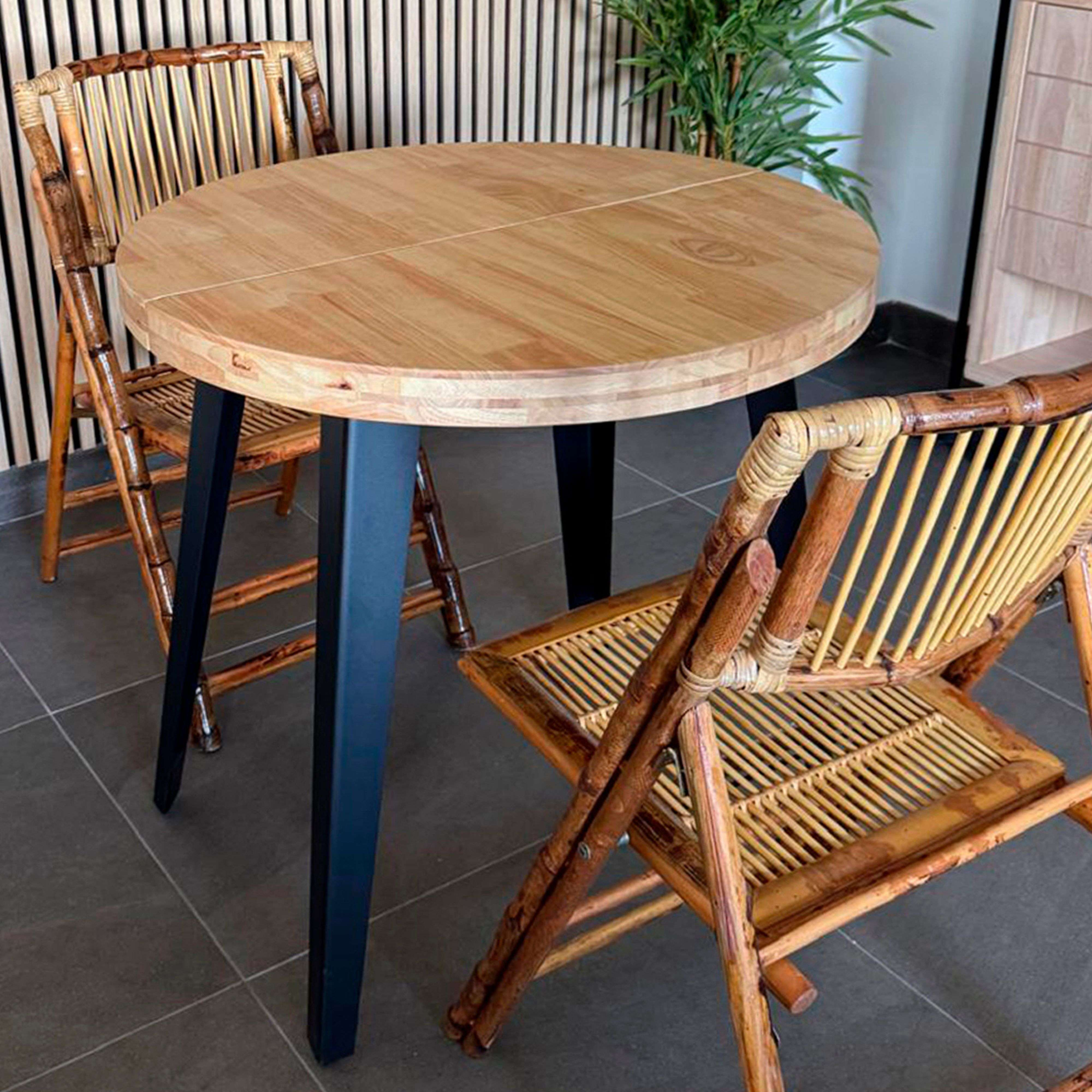 Mesa de madera con patas negras y dos sillas de ratán.
