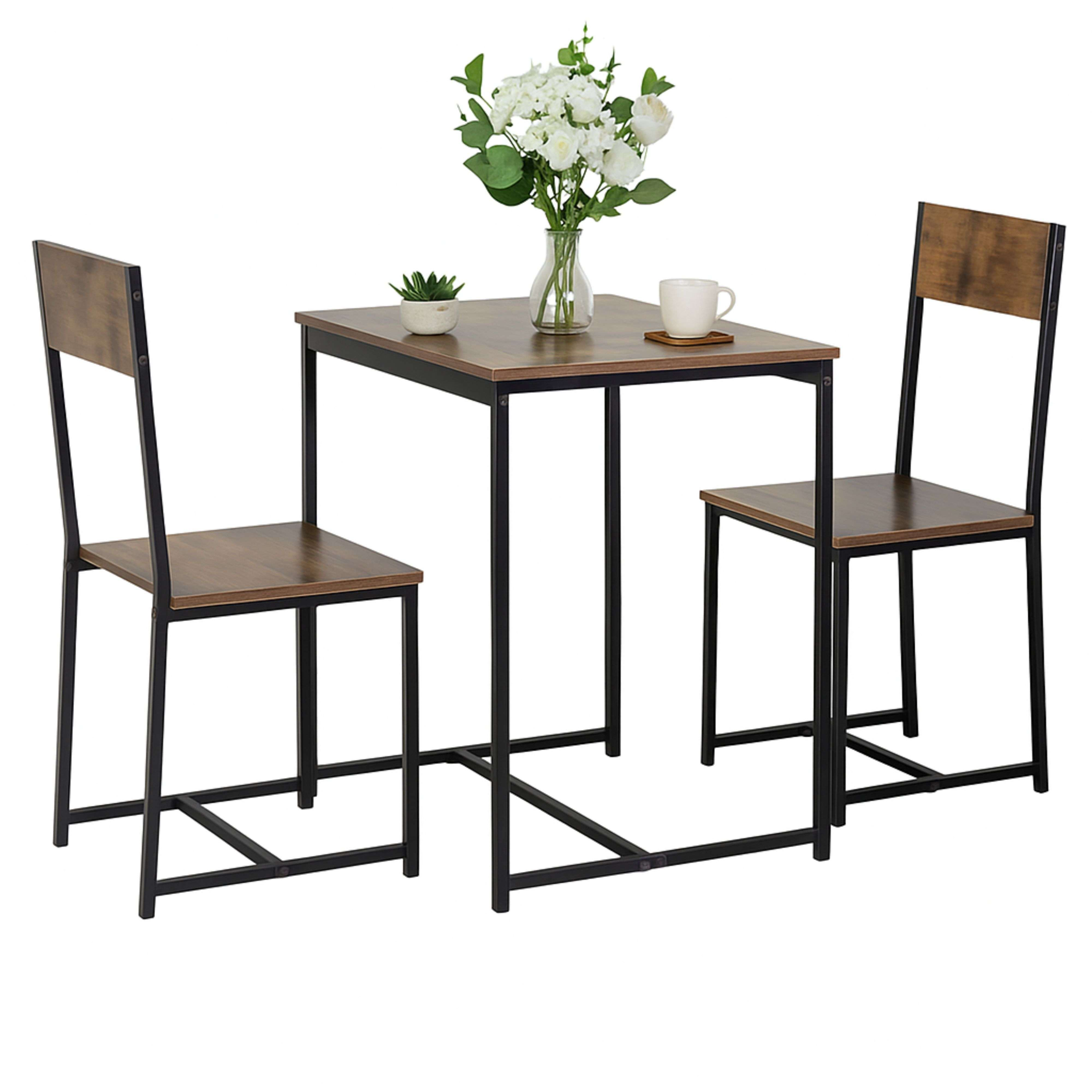 Una mesa pequeña de madera con dos sillas, decorada con flores y una taza.