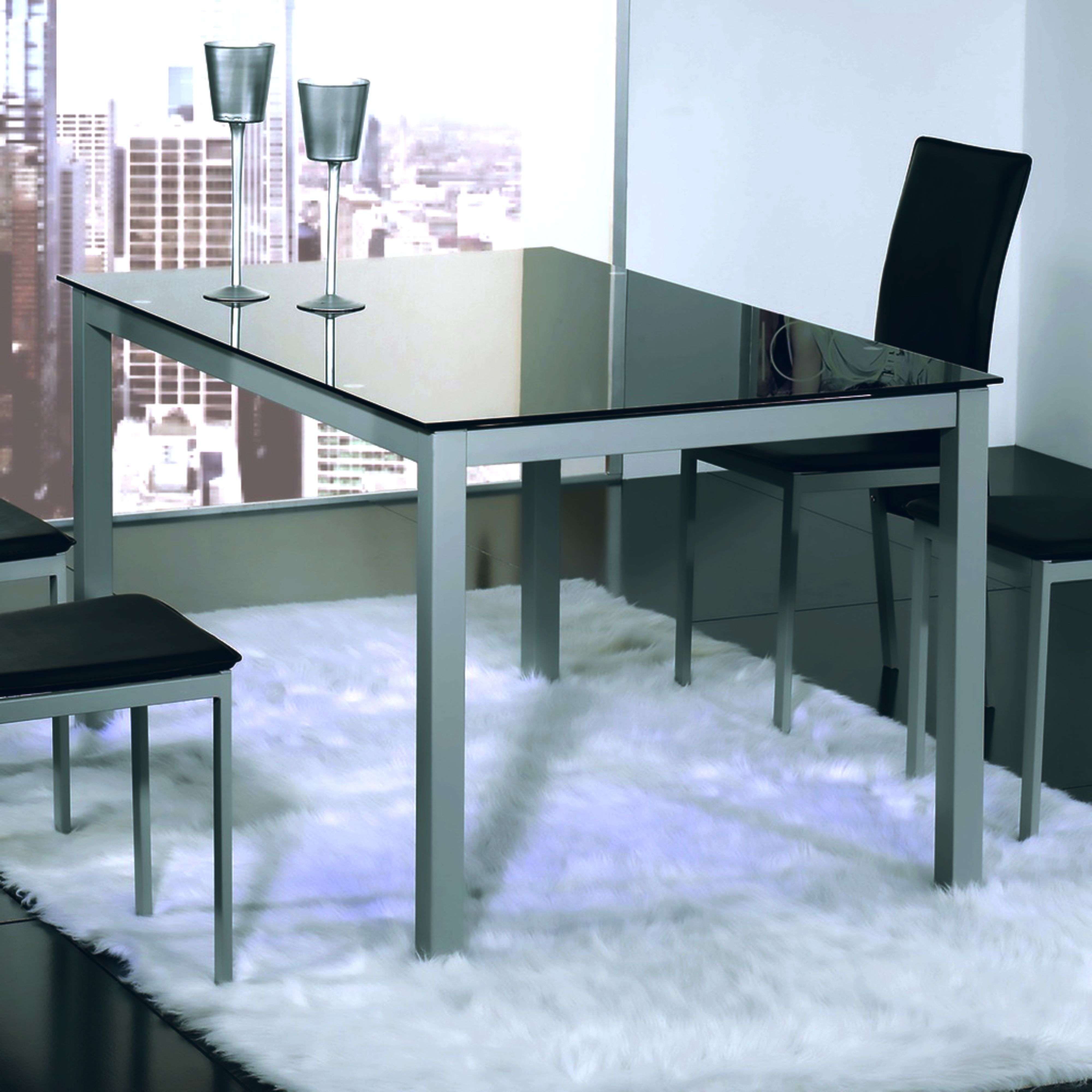 Mesa de comedor moderna con tapa de cristal, dos sillas y dos copas ante un paisaje urbano.