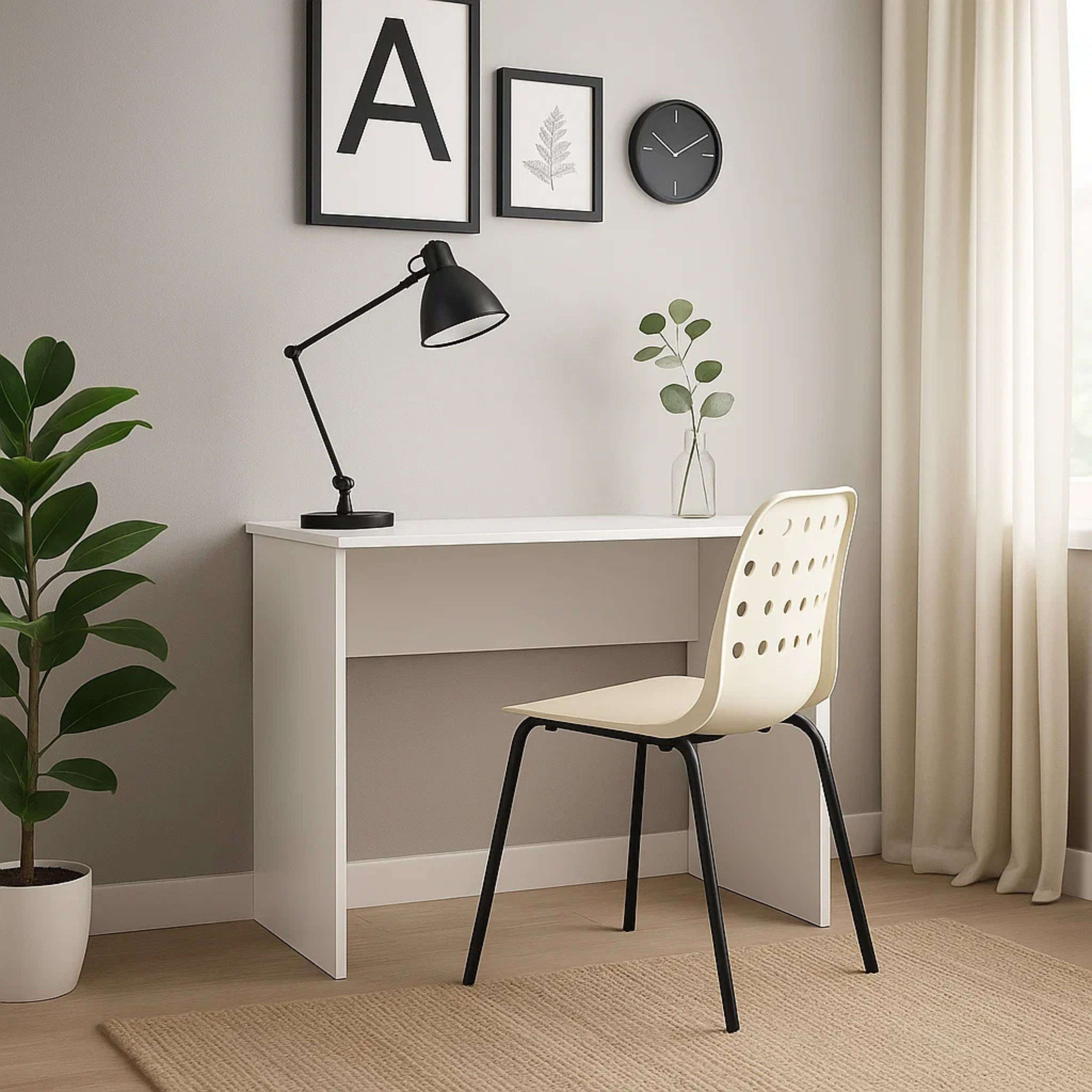 Un escritorio blanco con una lámpara de brazo negro, una silla y plantas.