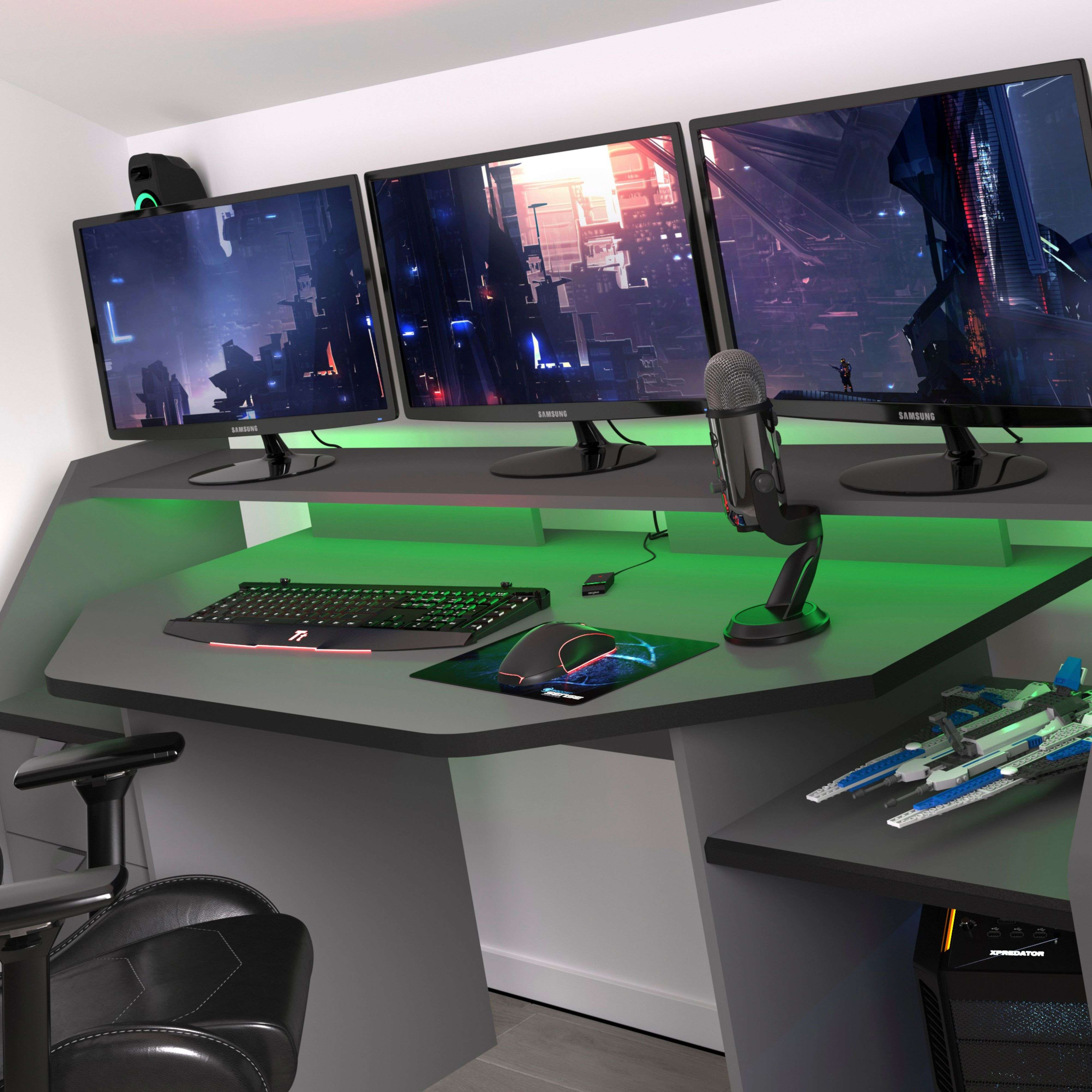 Un escritorio para juegos con tres monitores, teclado, ratón, micrófono y PC.