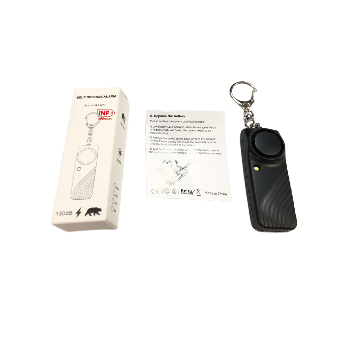 Ein schwarzer Selbstverteidigungsalarm mit Schlüsselring liegt neben seiner Verpackung.