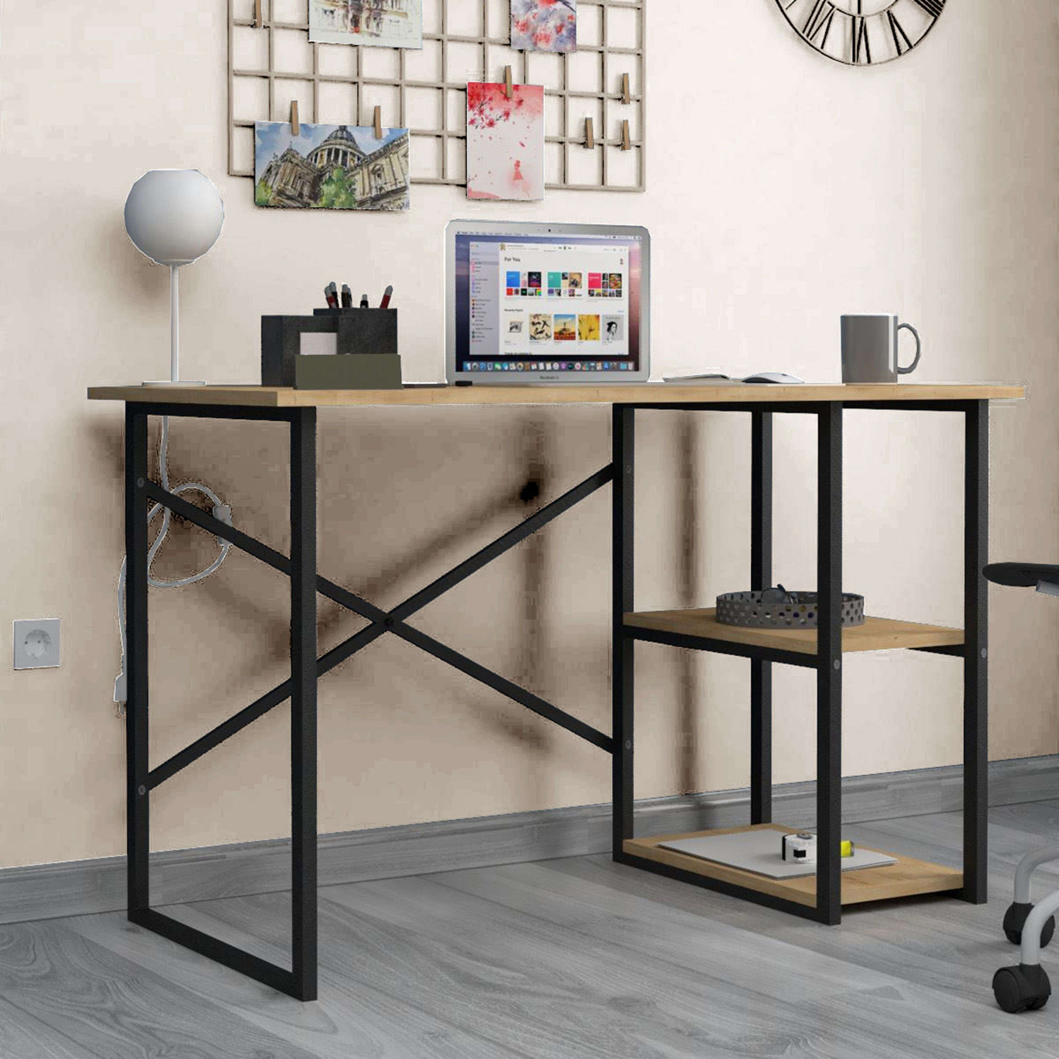 Un escritorio de madera con estructura de metal negro, portátil, lámpara, taza y decoraciones.