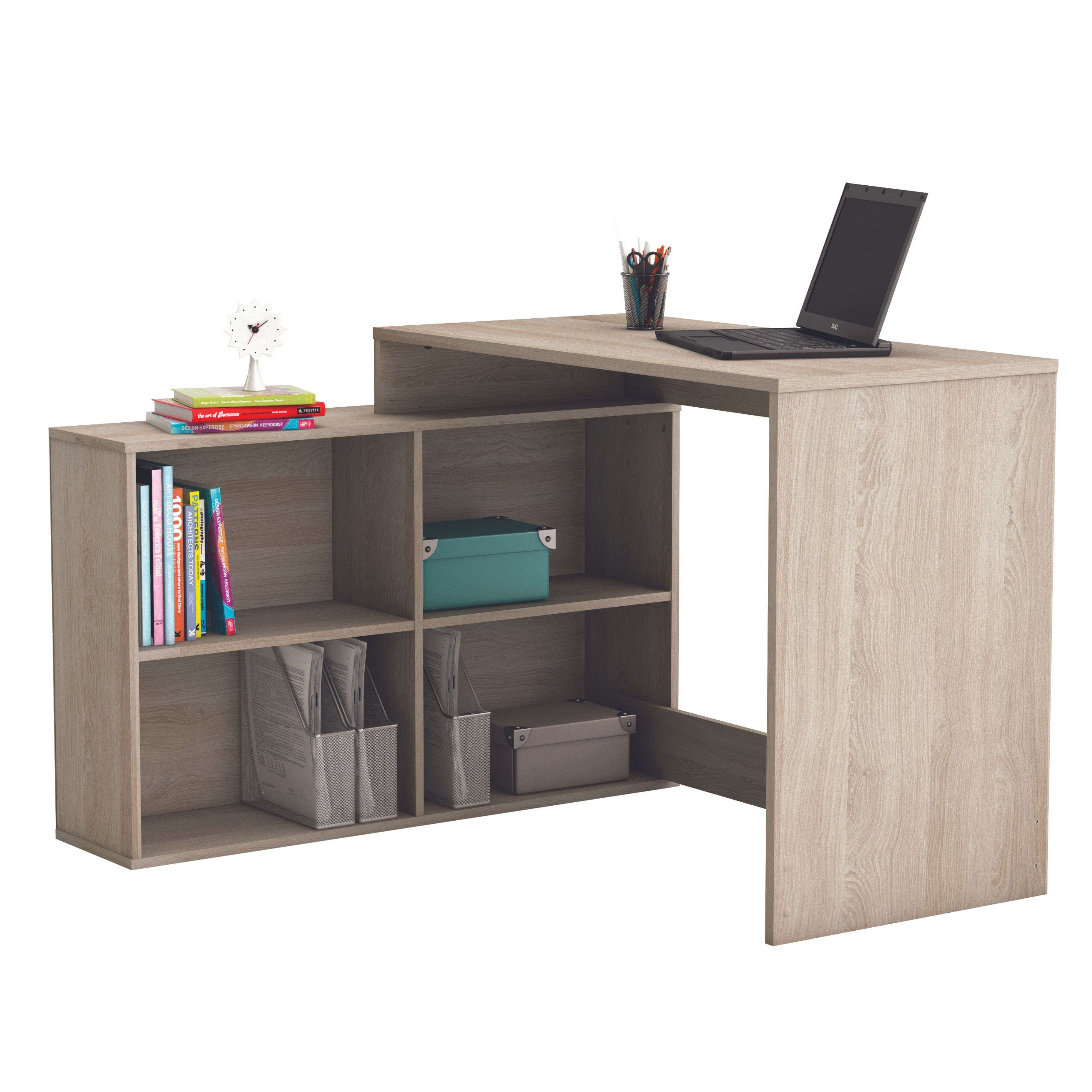Un escritorio de madera clara en forma de L con estantes, libros y un portátil.
