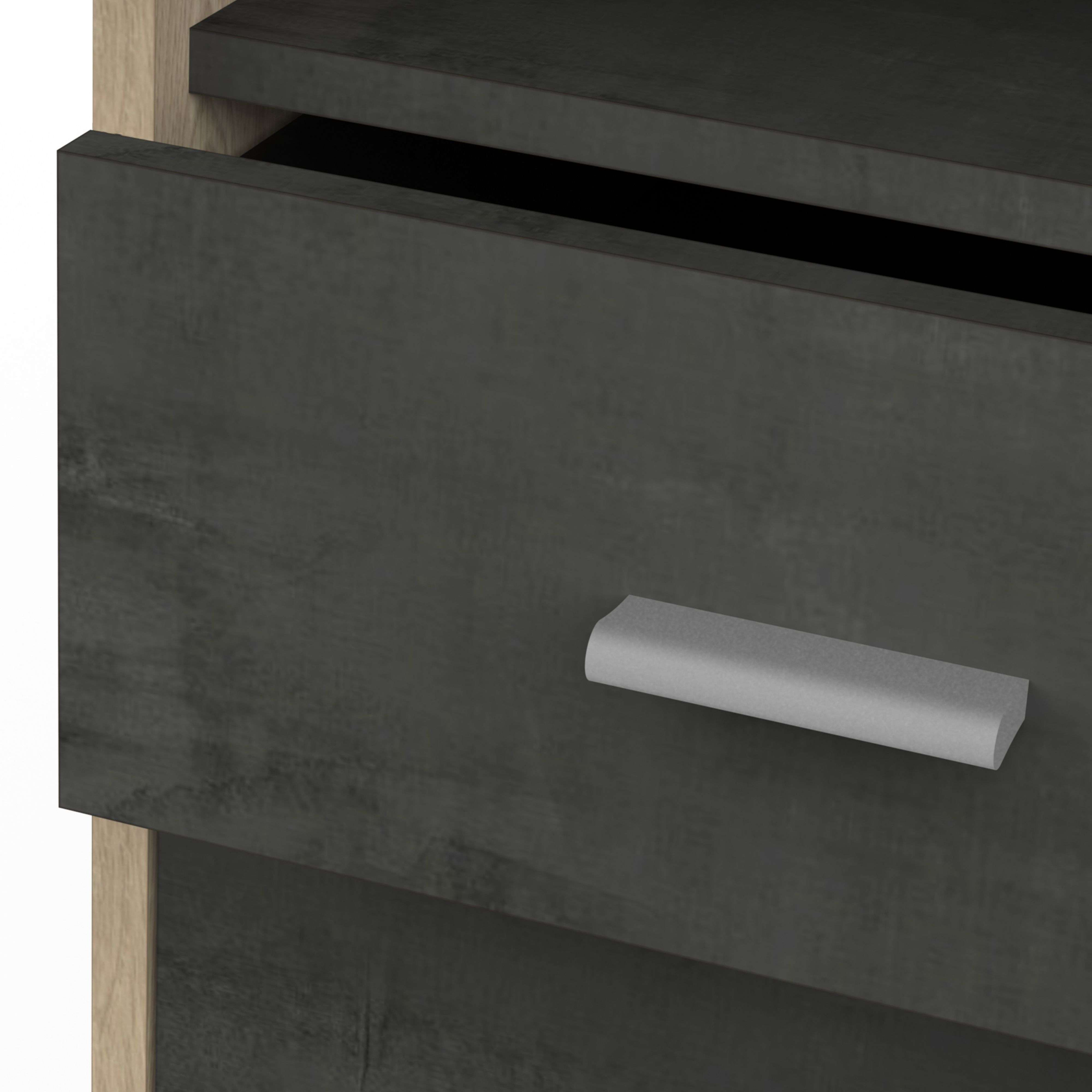 Un cajón oscuro con un tirador plateado y un borde de madera.