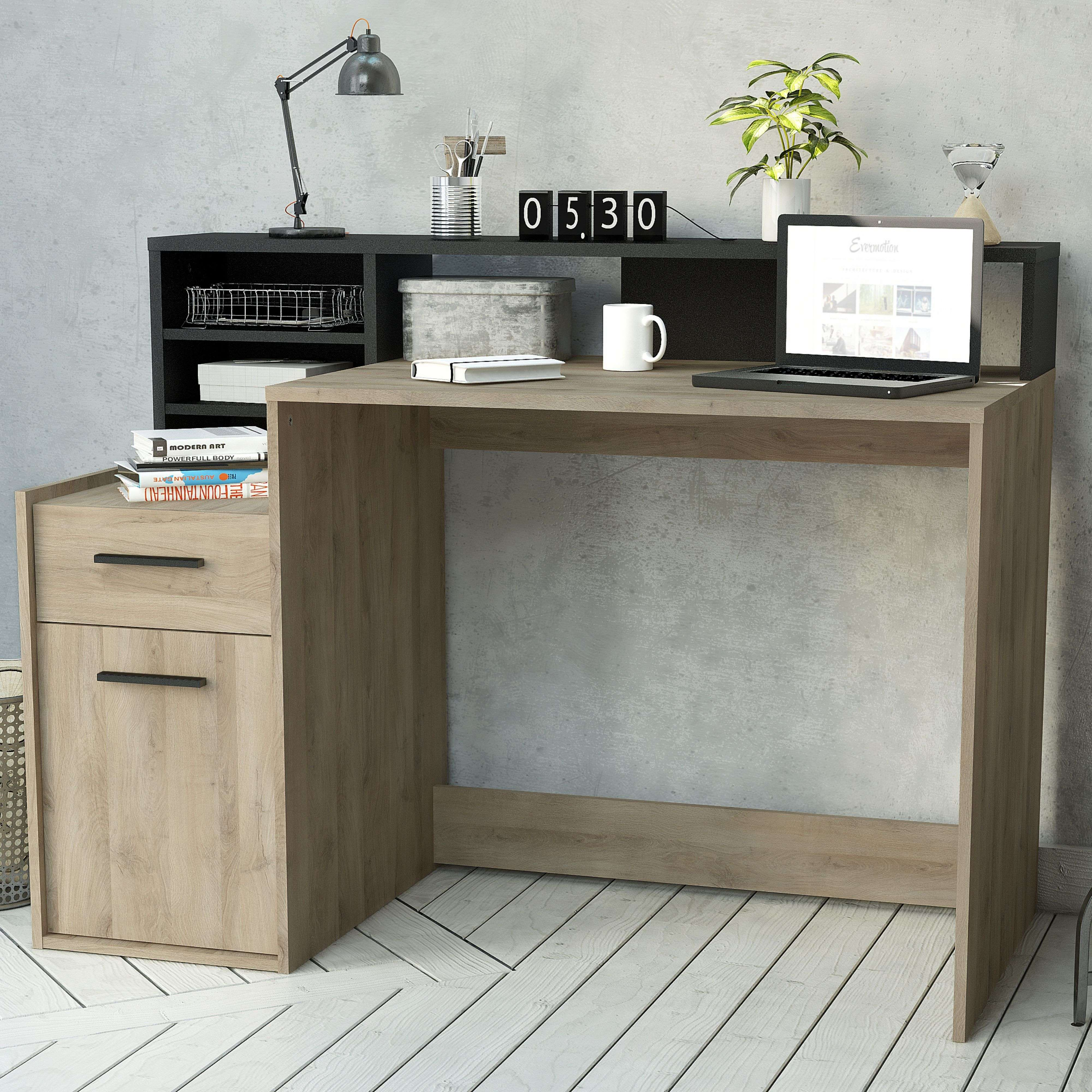Un escritorio de madera con portátil, taza, lámpara, reloj y planta.