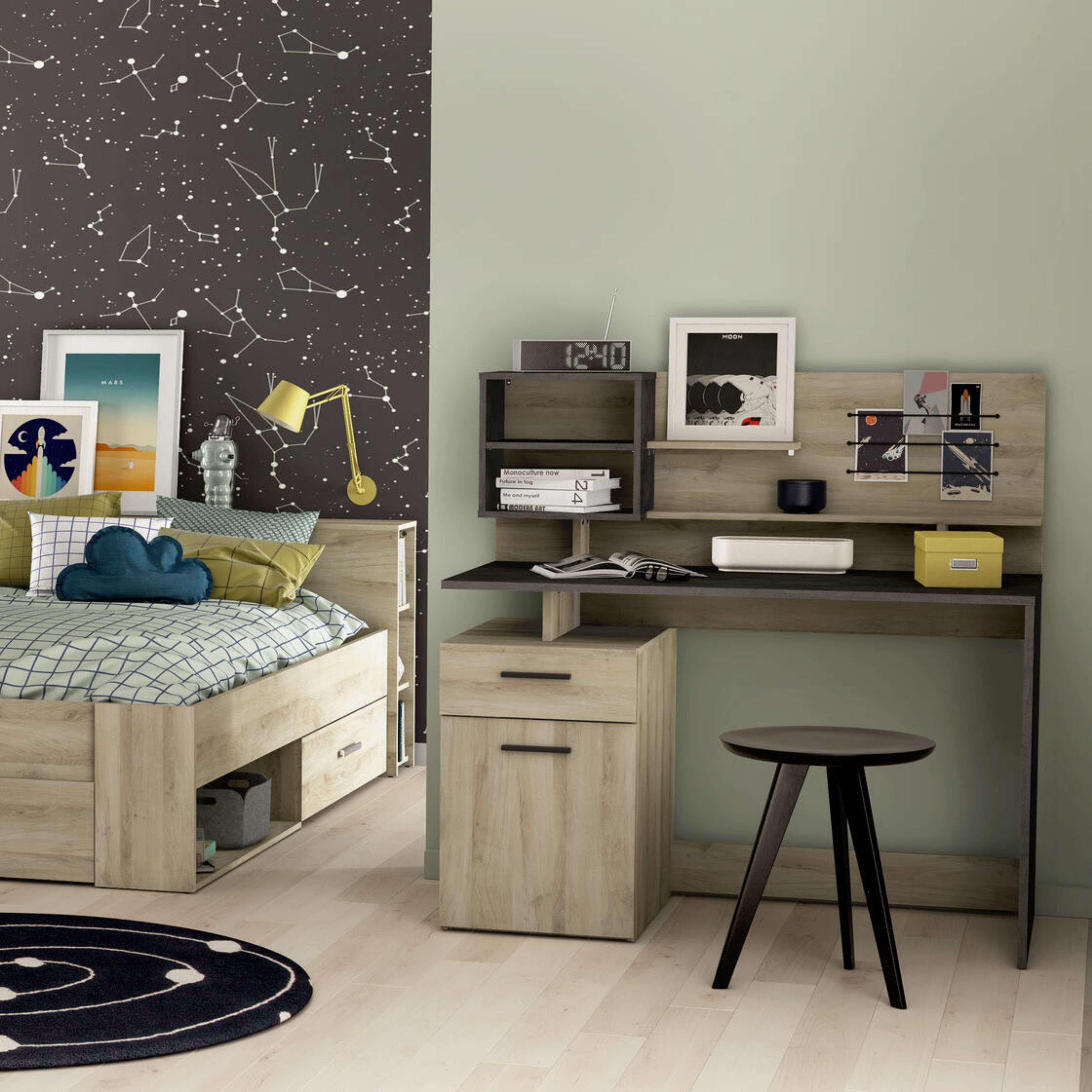 Un dormitorio juvenil con temática espacial, cama, escritorio y papel tapiz de estrellas.