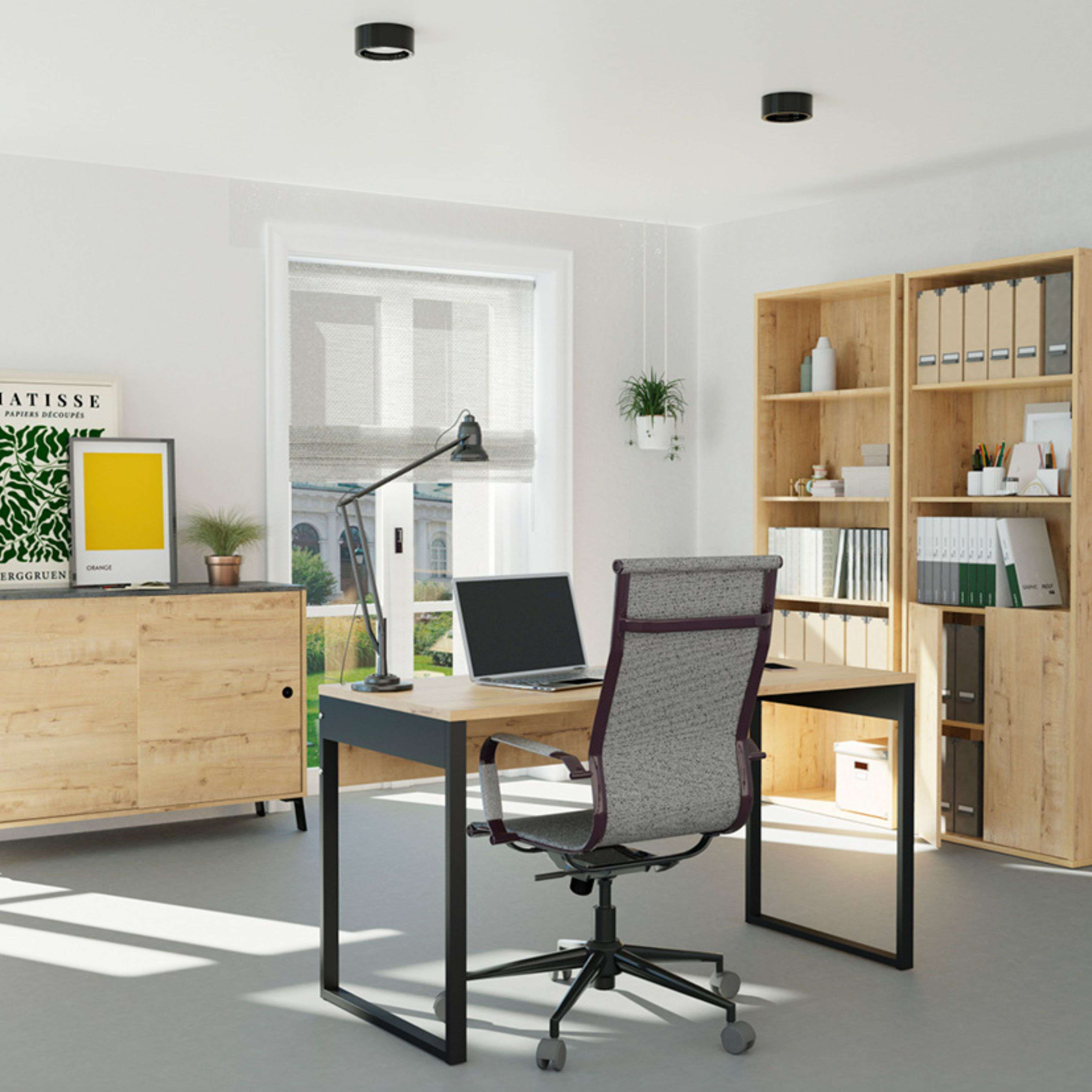 Oficina luminosa con escritorio, silla, estantería y ventana.
