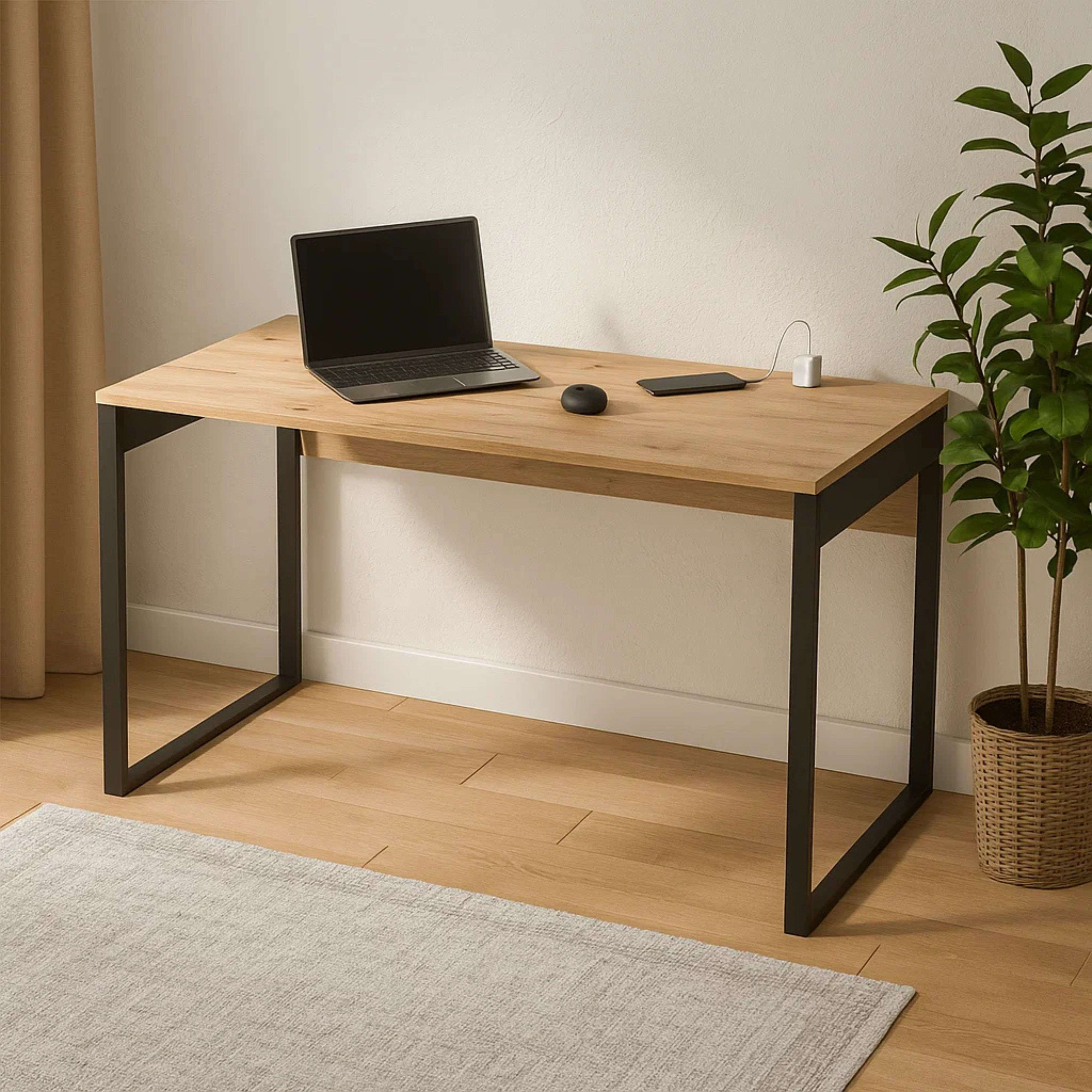 Un escritorio con laptop, teléfono, ratón y planta en maceta.