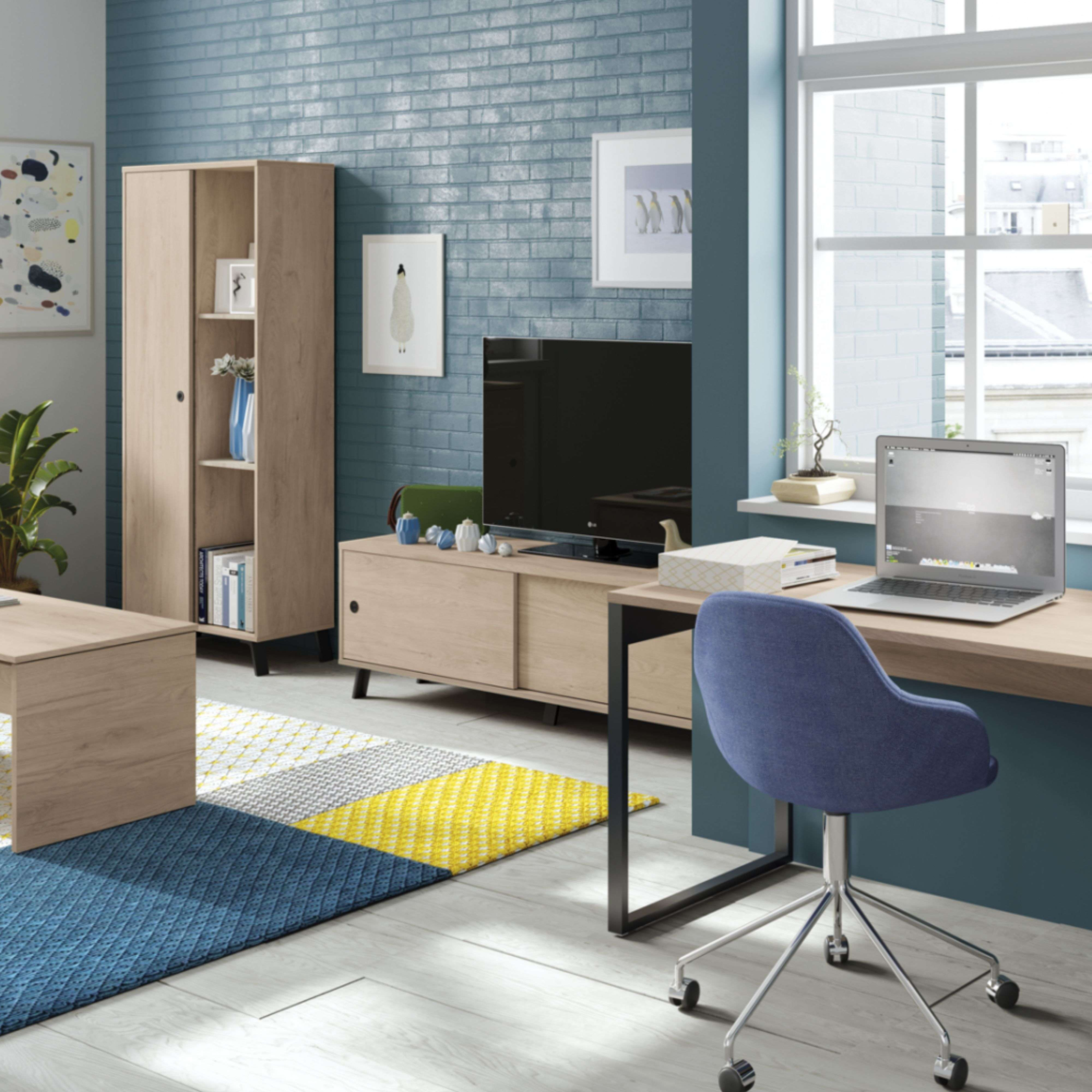 Una sala de estar luminosa con pared de ladrillo azul, muebles de madera y portátil.