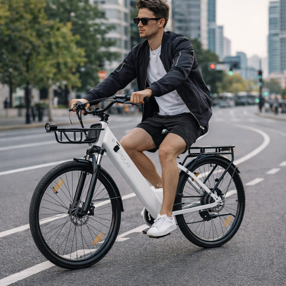 Mężczyzna jedzie na białym rowerze elektrycznym po miejskiej ulicy z wysokimi budynkami w tle.