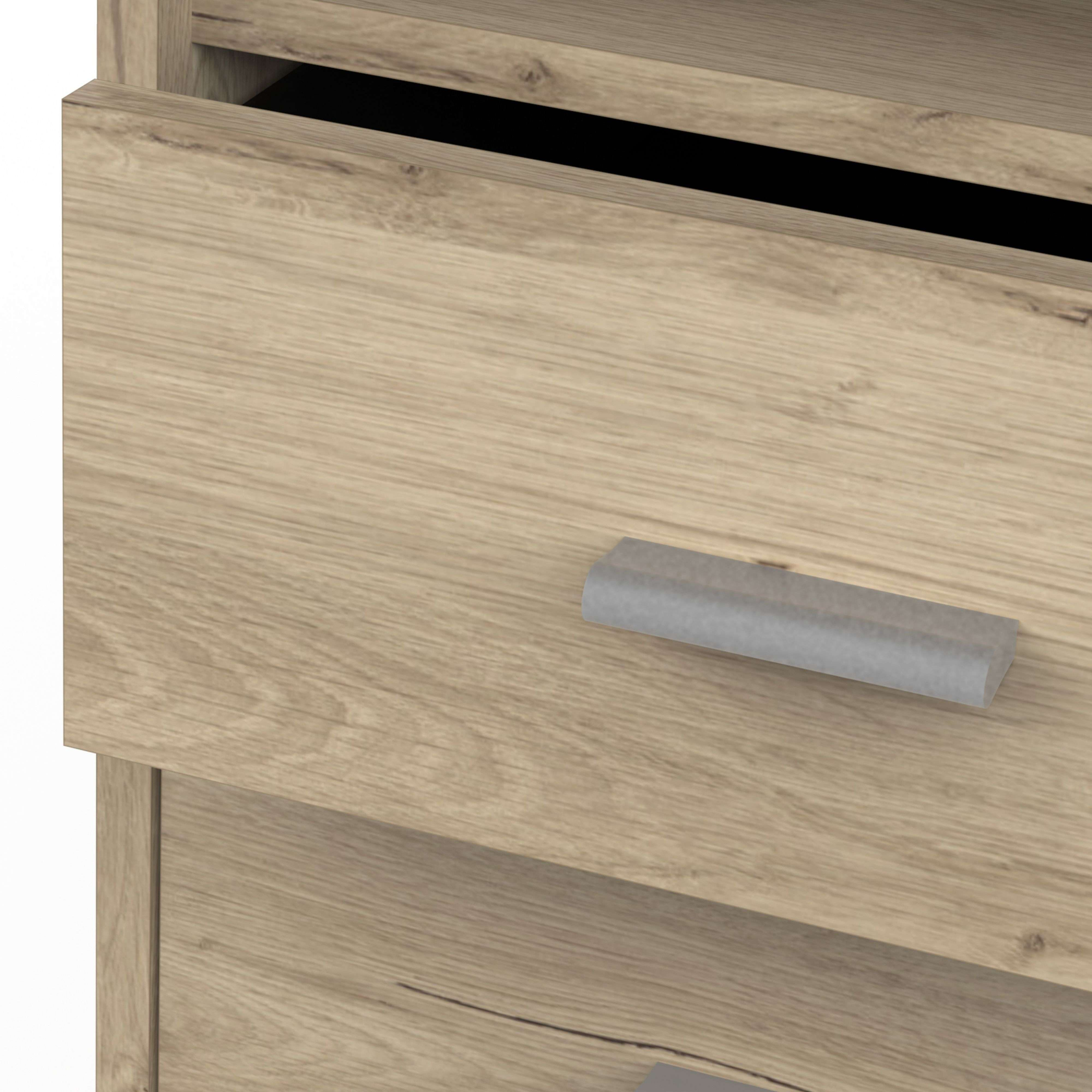 Un primer plano de un cajón de madera con un tirador plateado.
