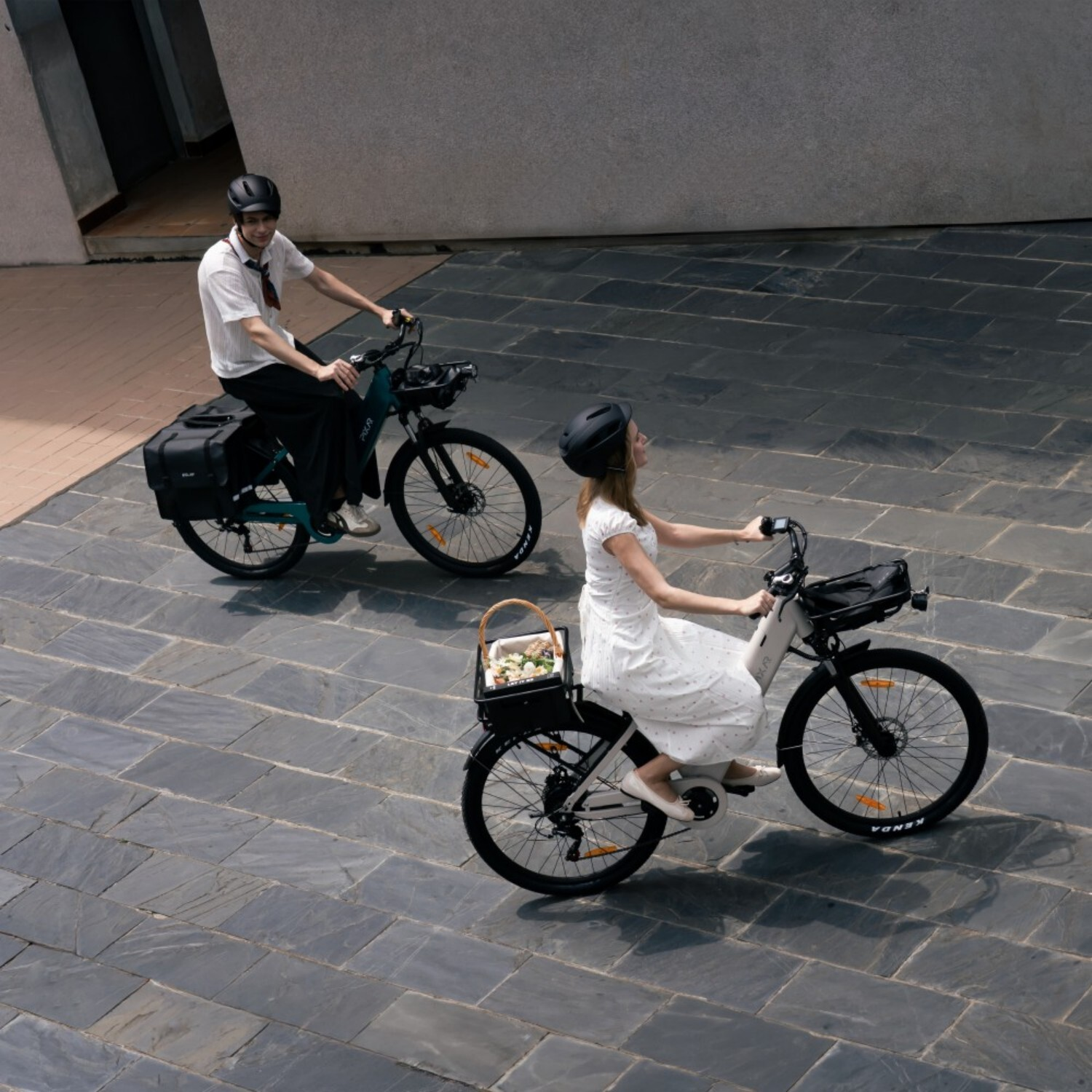 Mężczyzna i kobieta jadą rowerami obok siebie, oboje w kaskach.