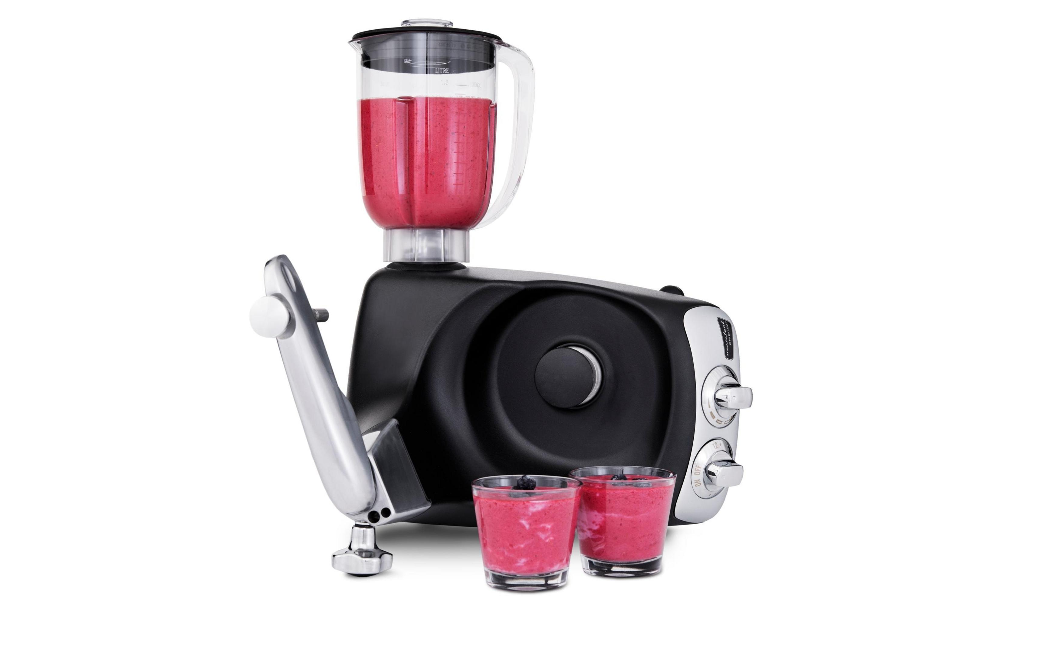 Ein schwarzer Mixer mit einer Karaffe, gefüllt mit rotem Smoothie, daneben zwei Gläser.