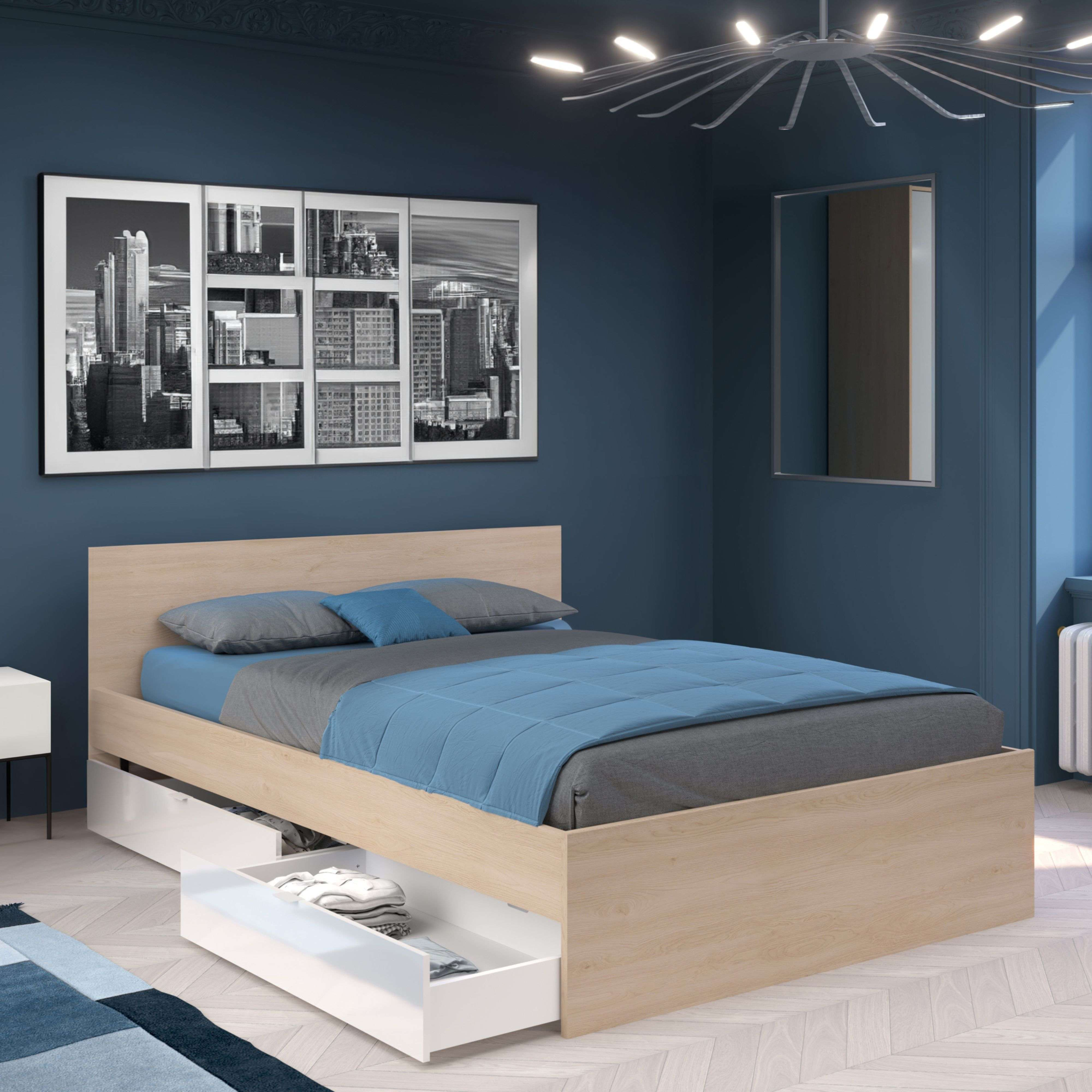 Una cama de madera con ropa de cama azul está en una habitación azul.