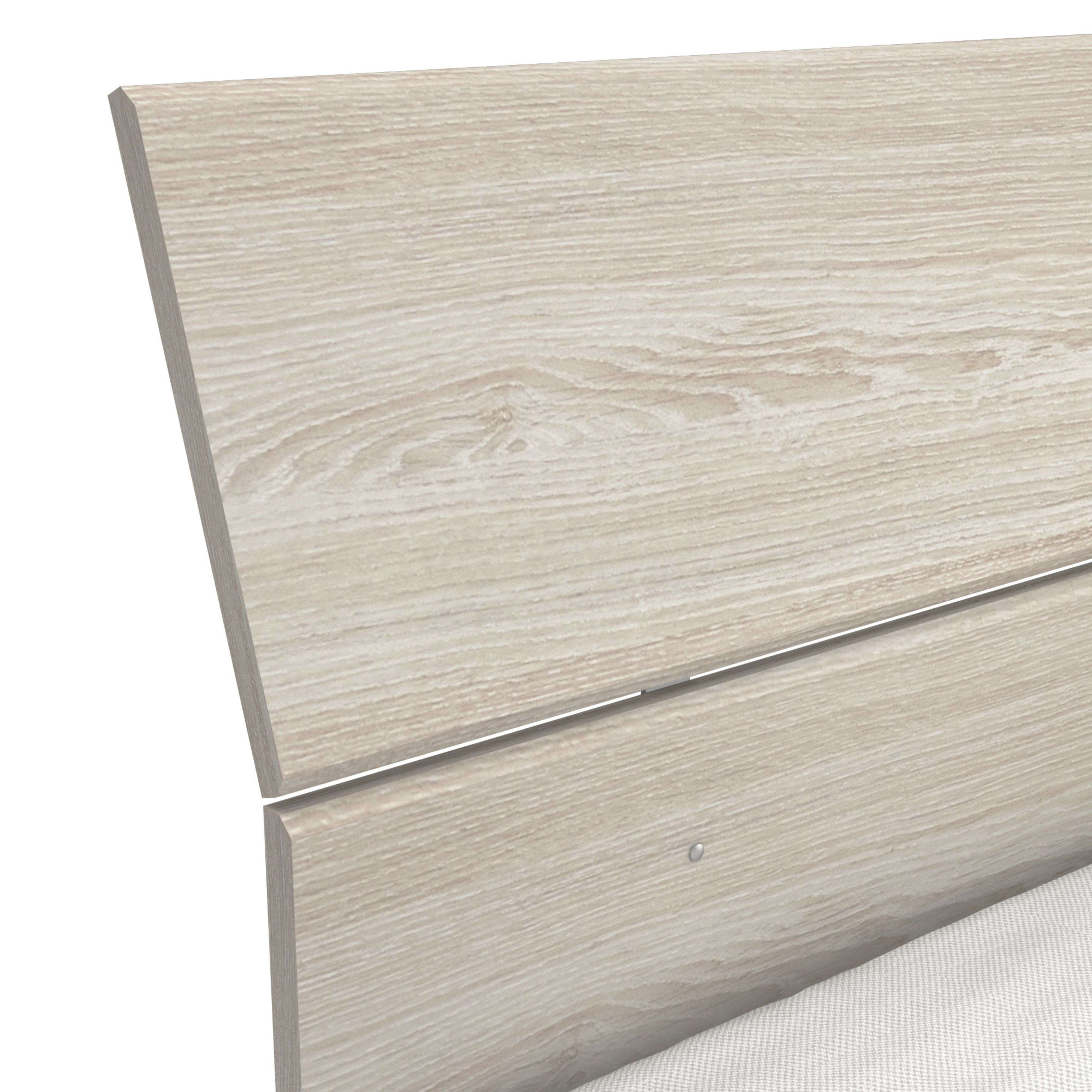 Primer plano de un cabecero de madera clara con un colchón texturizado blanco.