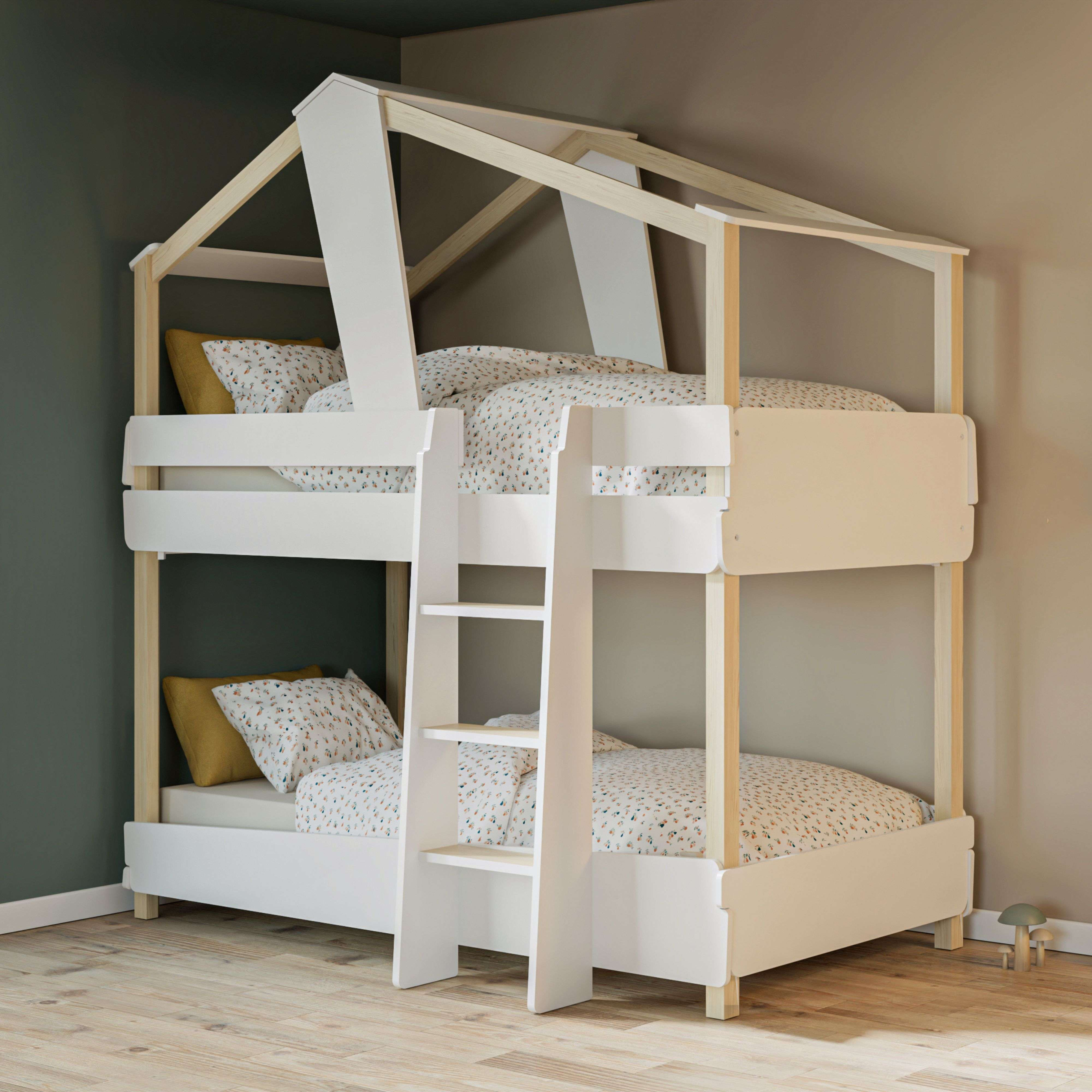 Una litera blanca con estructura de techo de casa y escalera. Con ropa de cama estampada.