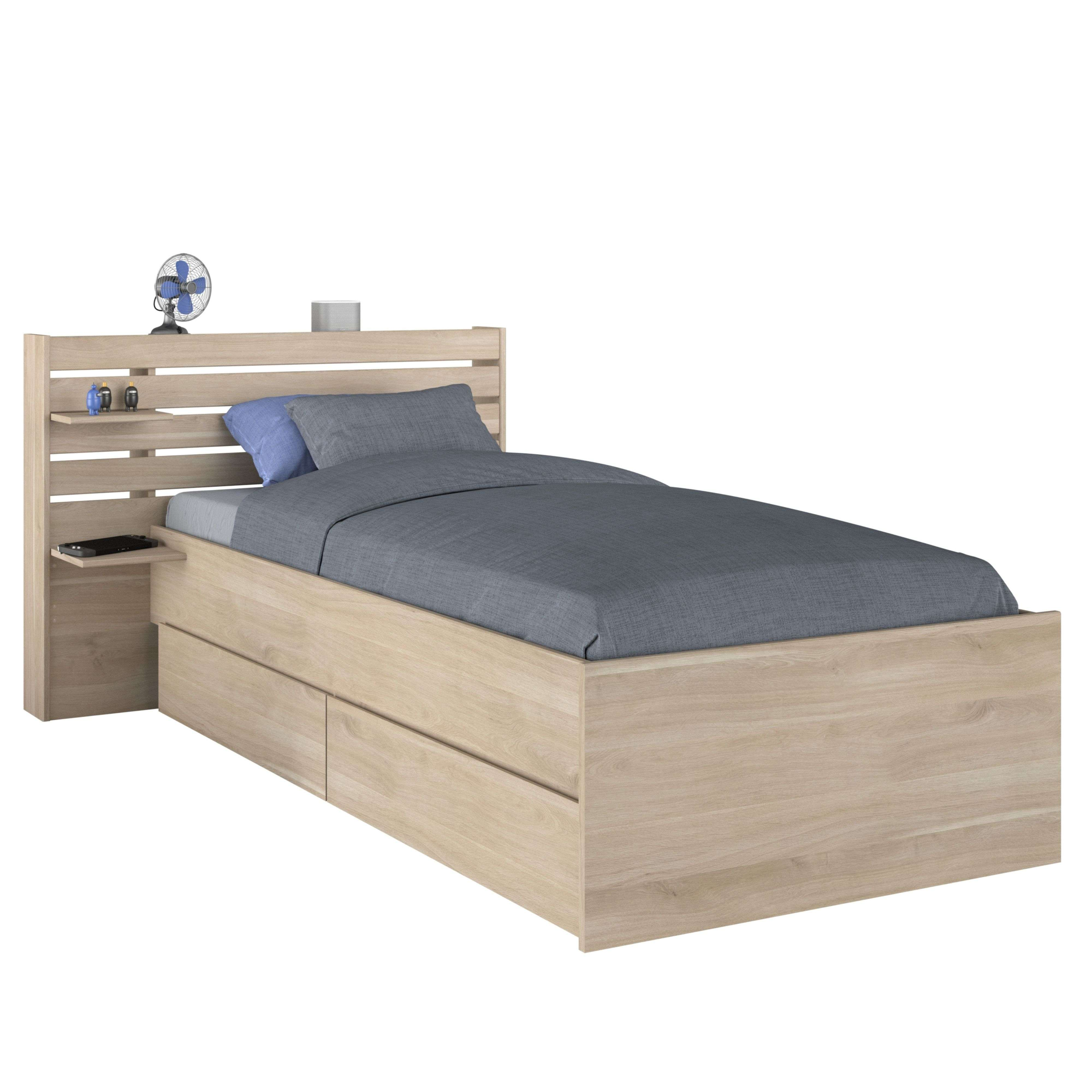 Una cama individual de madera clara con dos almohadas azules y edredón gris.