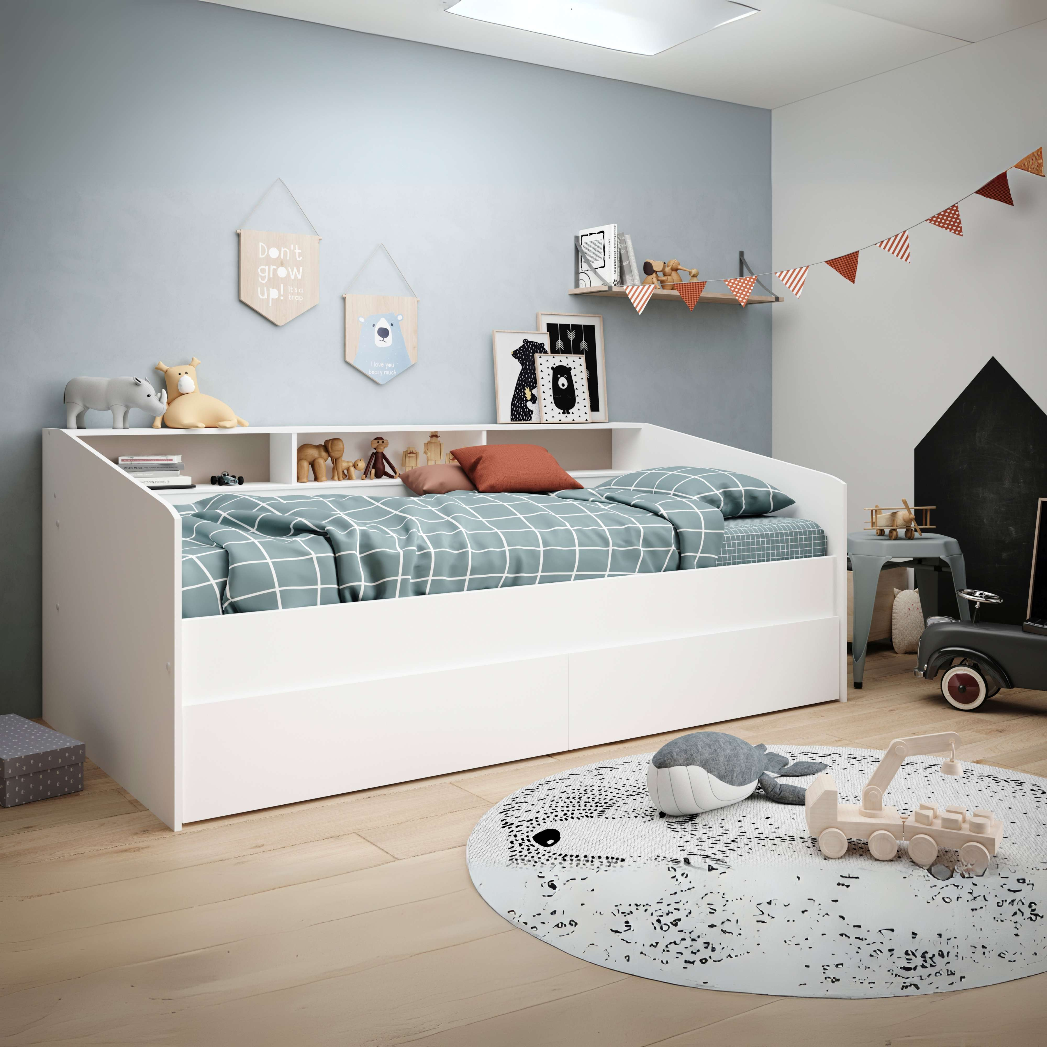 Habitación infantil con cama blanca, juguetes y decoración de osos en la pared.