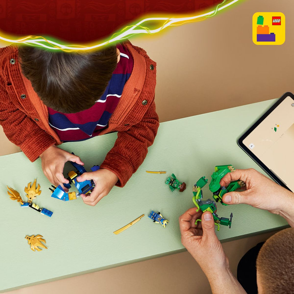 Niños construyen con Lego sobre una mesa. Una tableta está al lado.