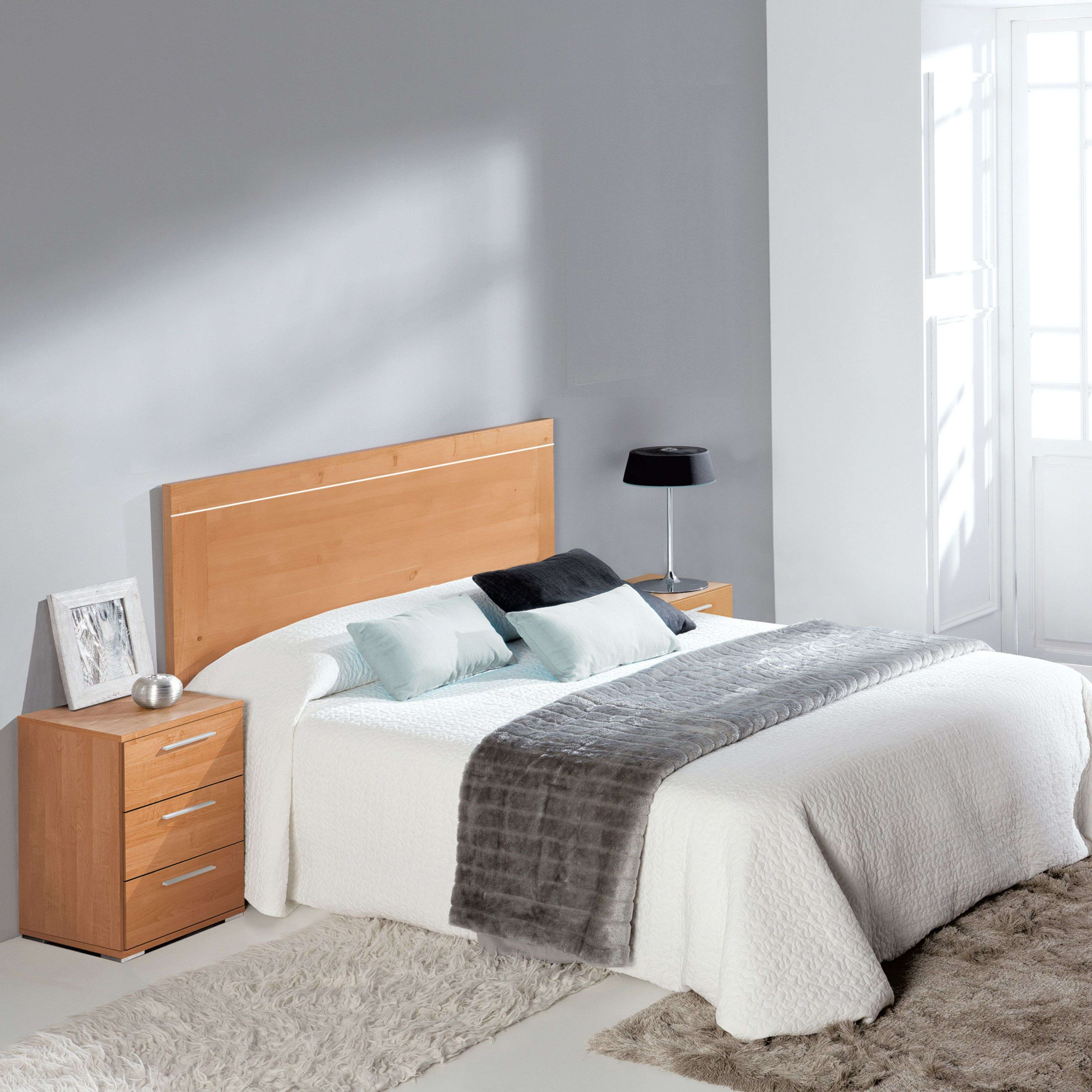 Un dormitorio con cama doble, mesitas de noche, lámpara y alfombras.