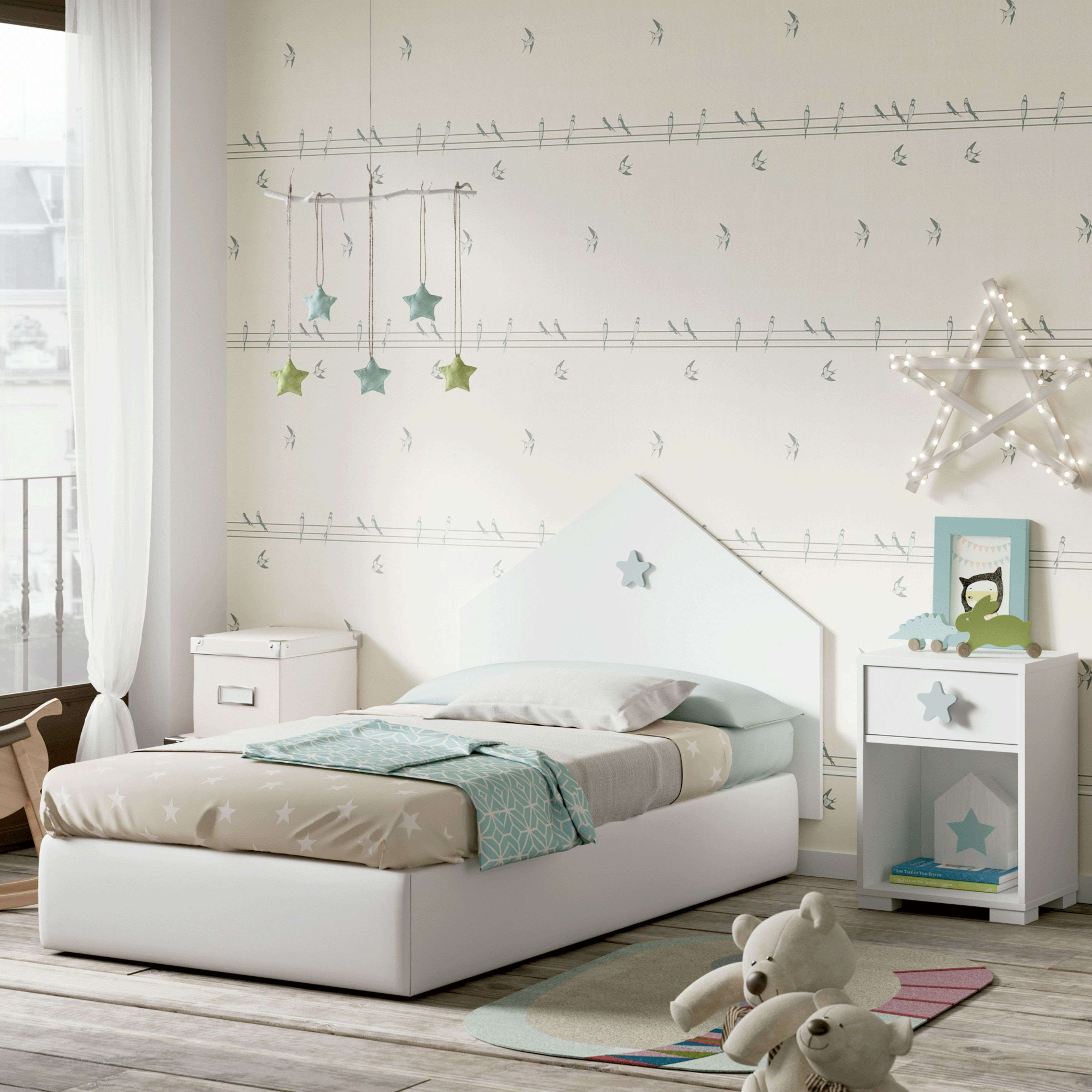 Dormitorio infantil con cama blanca, ropa de cama de estrellas y papel pintado de pájaros.